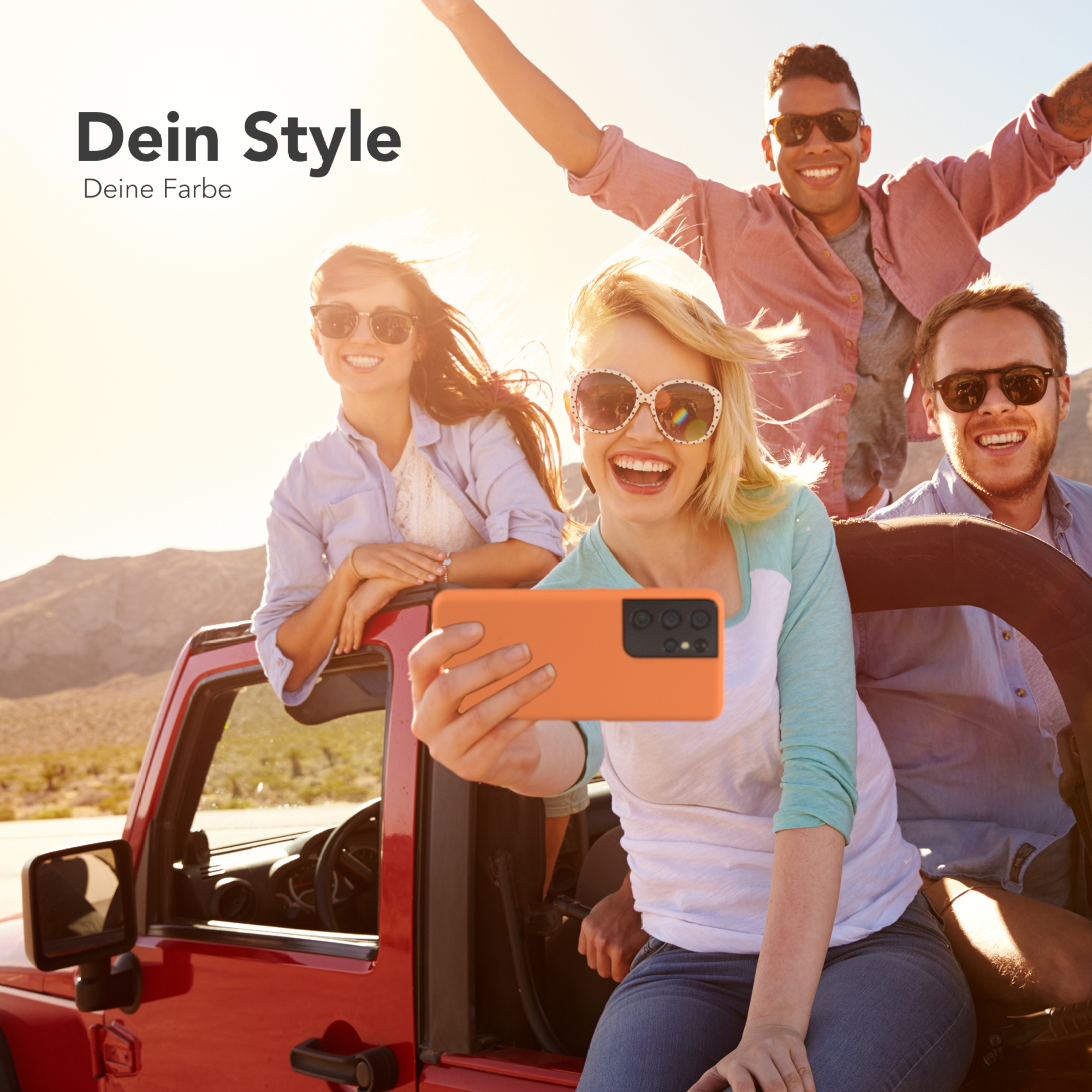 Vier Personen in einem roten Jeep machen ein Selfie. Orangefarbene Handyhülle, blauer Himmel.