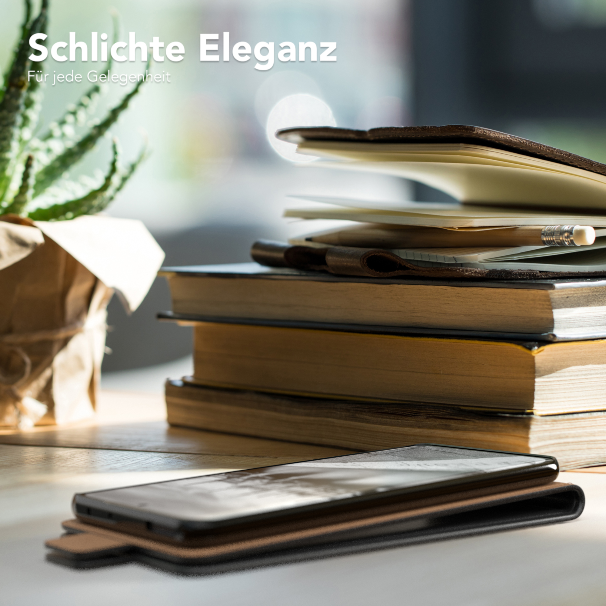 Ein Telefon in einer braunen Lederhülle liegt auf einem Holztisch mit Büchern und einer Pflanze, zeigt schlichte Eleganz.