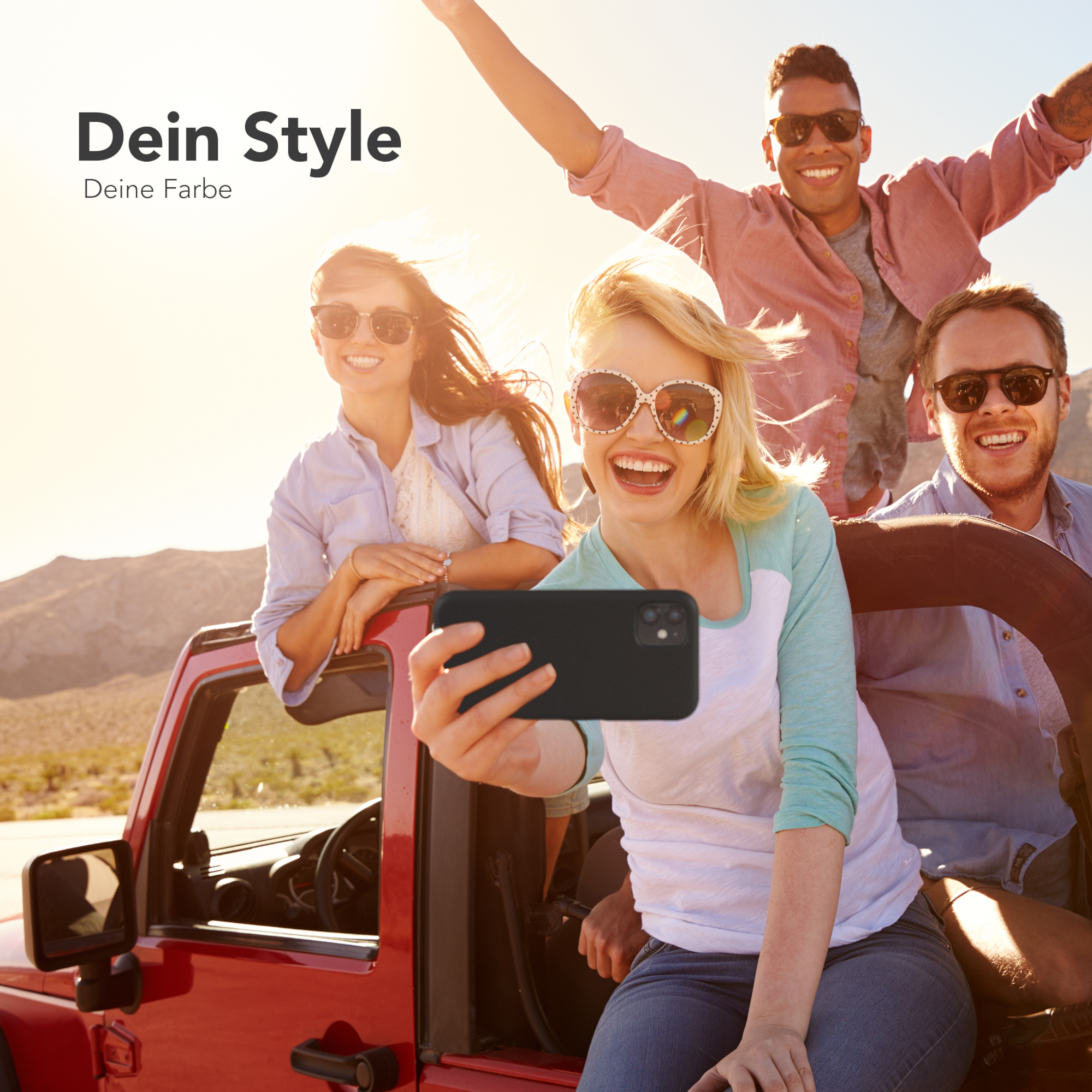 Vier Personen posieren für ein Selfie in einem roten Jeep.