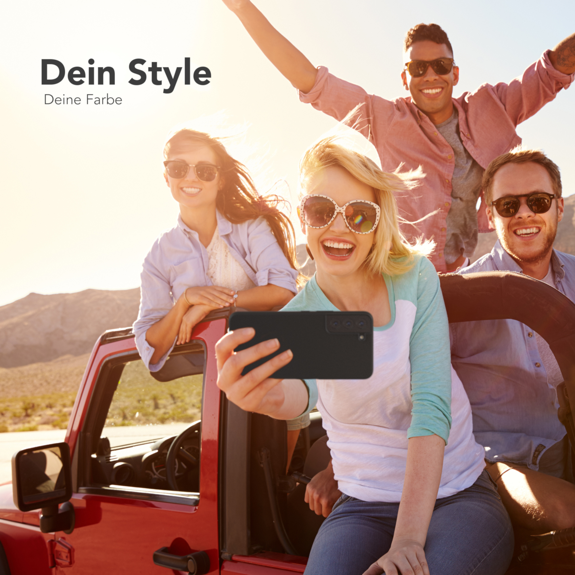 Vier Personen in einem roten Jeep machen ein Selfie. Einer hält eine schwarze Handyhülle.