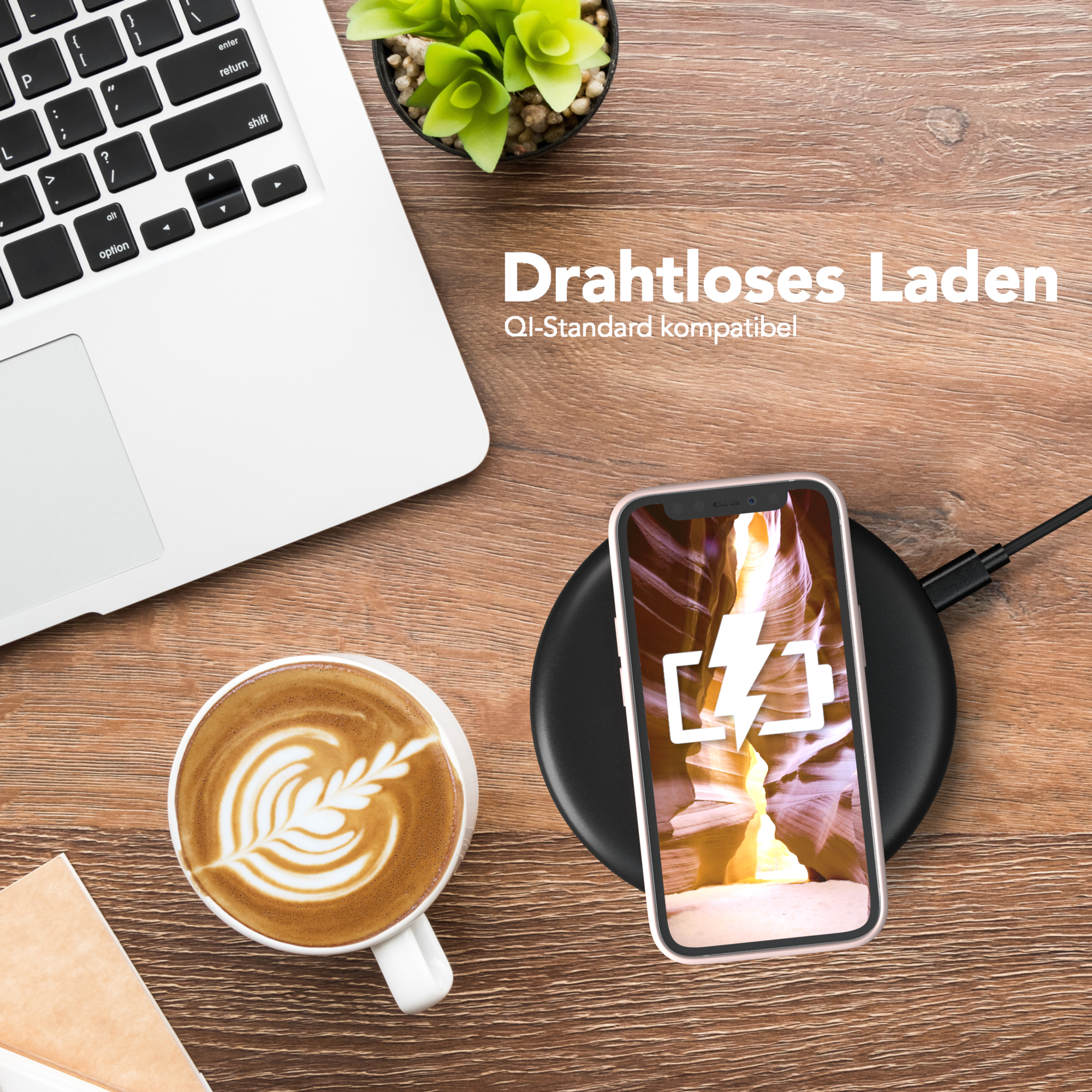 Laptop, Kaffee und Telefon auf einem Holzschreibtisch. Telefon wird kabellos geladen.