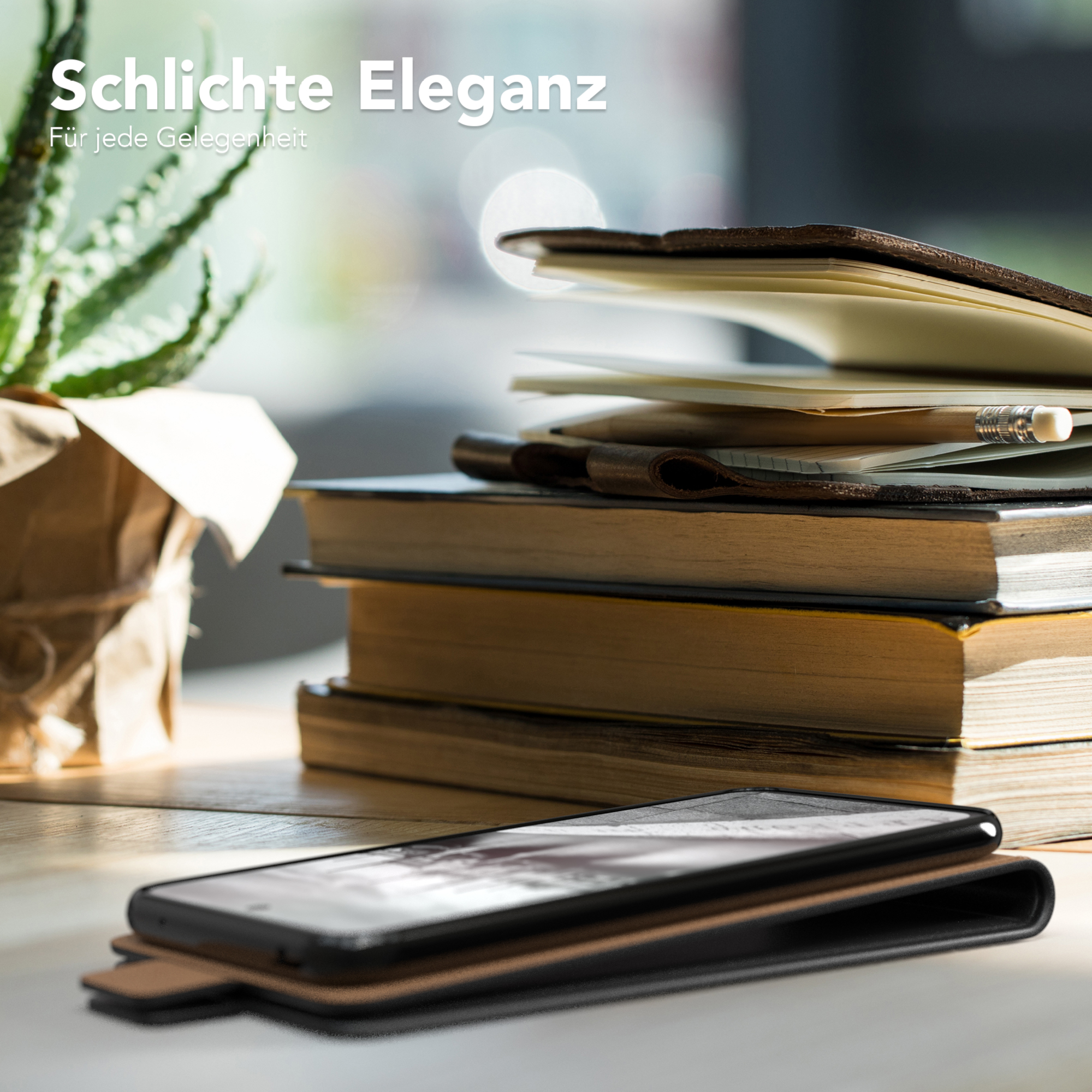 Ein Telefon in einer braunen Hülle auf einem Holztisch, Bücher und eine Pflanze im Hintergrund.