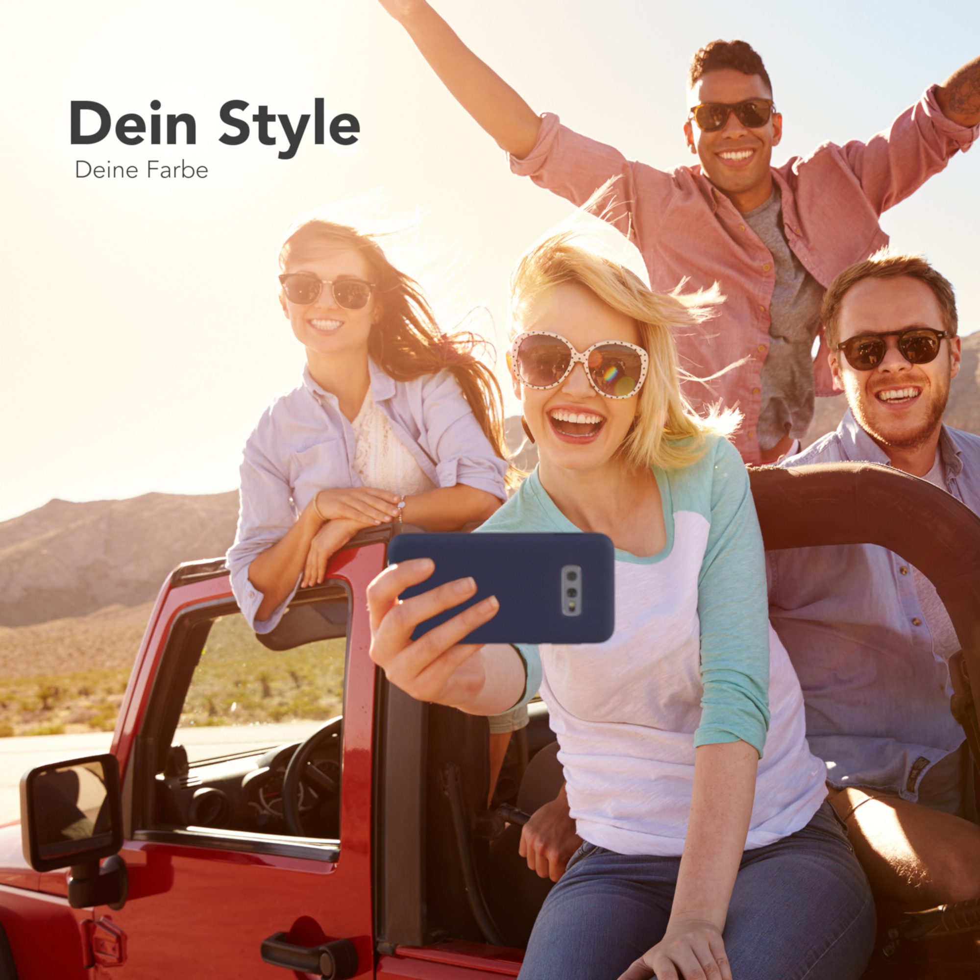 Vier Personen posieren in einem roten Jeep. Eine Person macht ein Selfie mit dem Handy. Sonniger Hintergrund.
