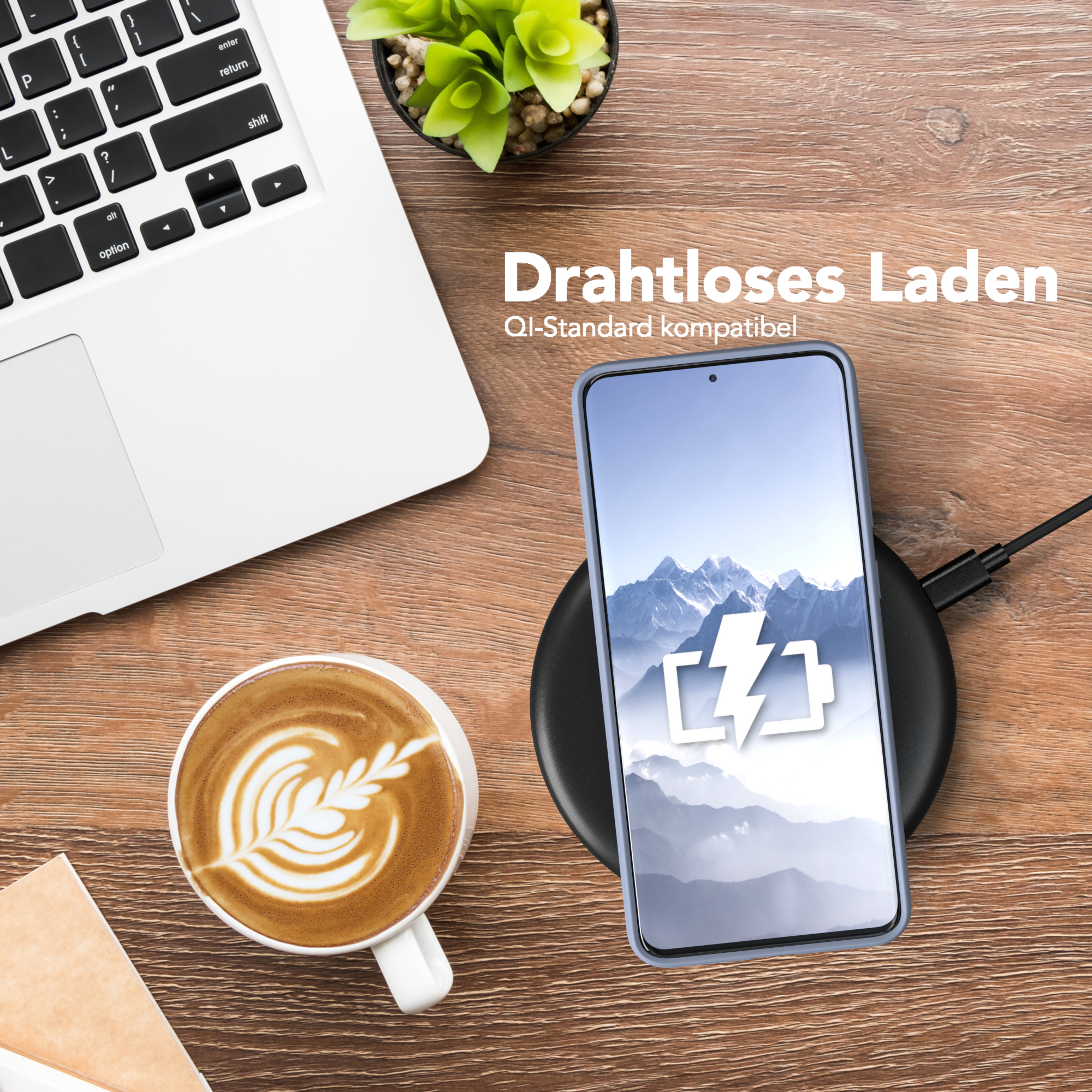 Telefon auf kabellosem Ladegerät, neben Kaffeetasse, Holztisch. Berge Hintergrund.
