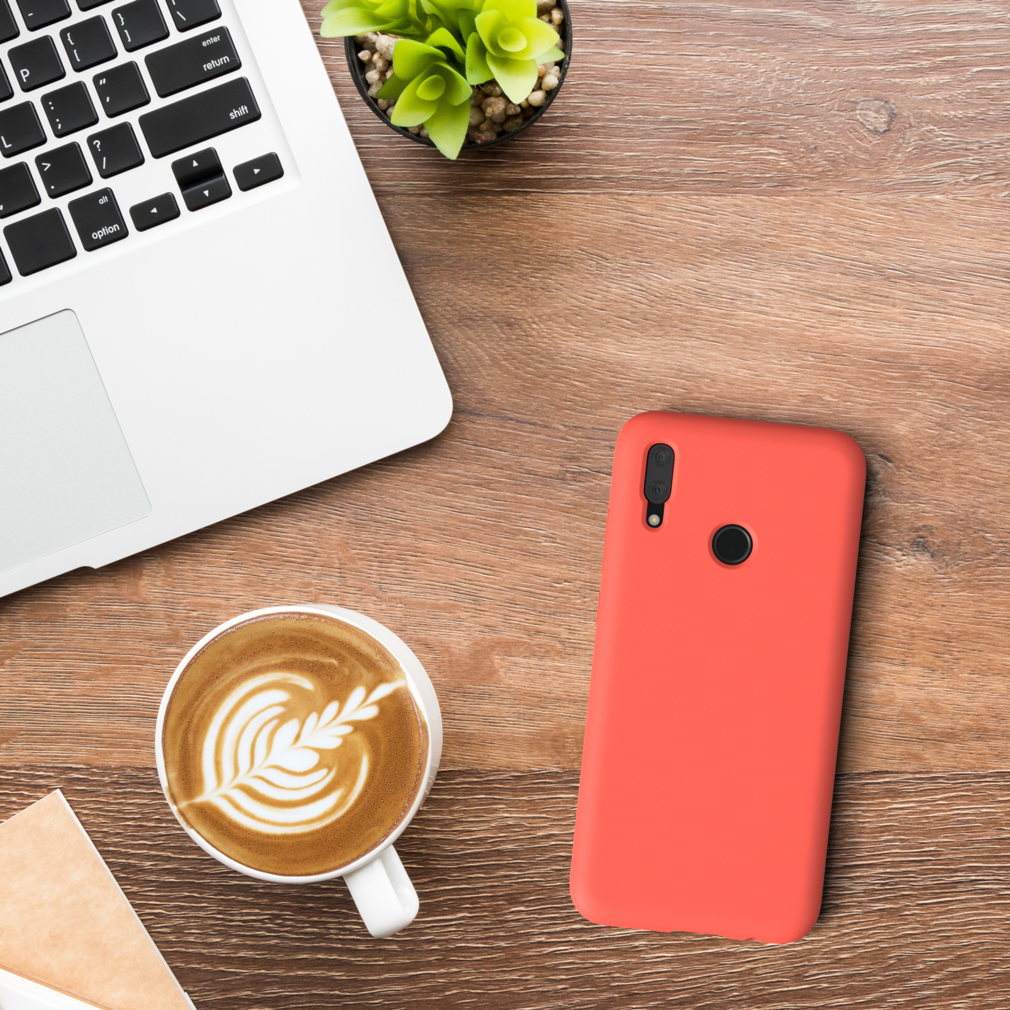 Laptop, Kaffee und eine rote Handyhülle auf einem Holztisch.