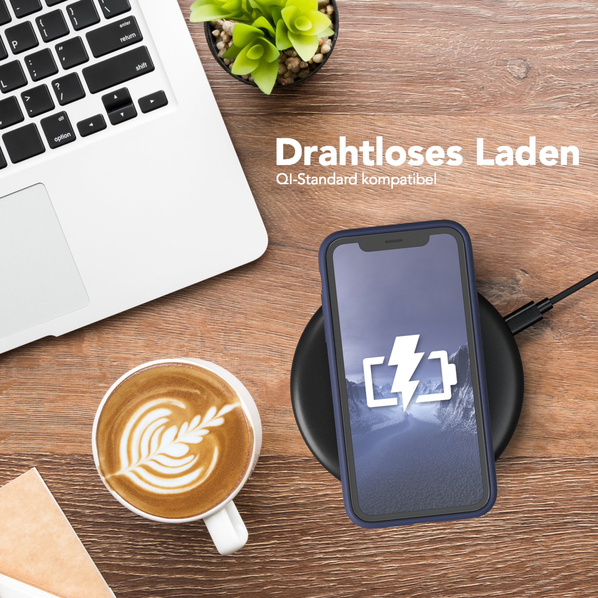 Telefon wird kabellos geladen, mit Laptop, Kaffee und Pflanze auf einem Holztisch.