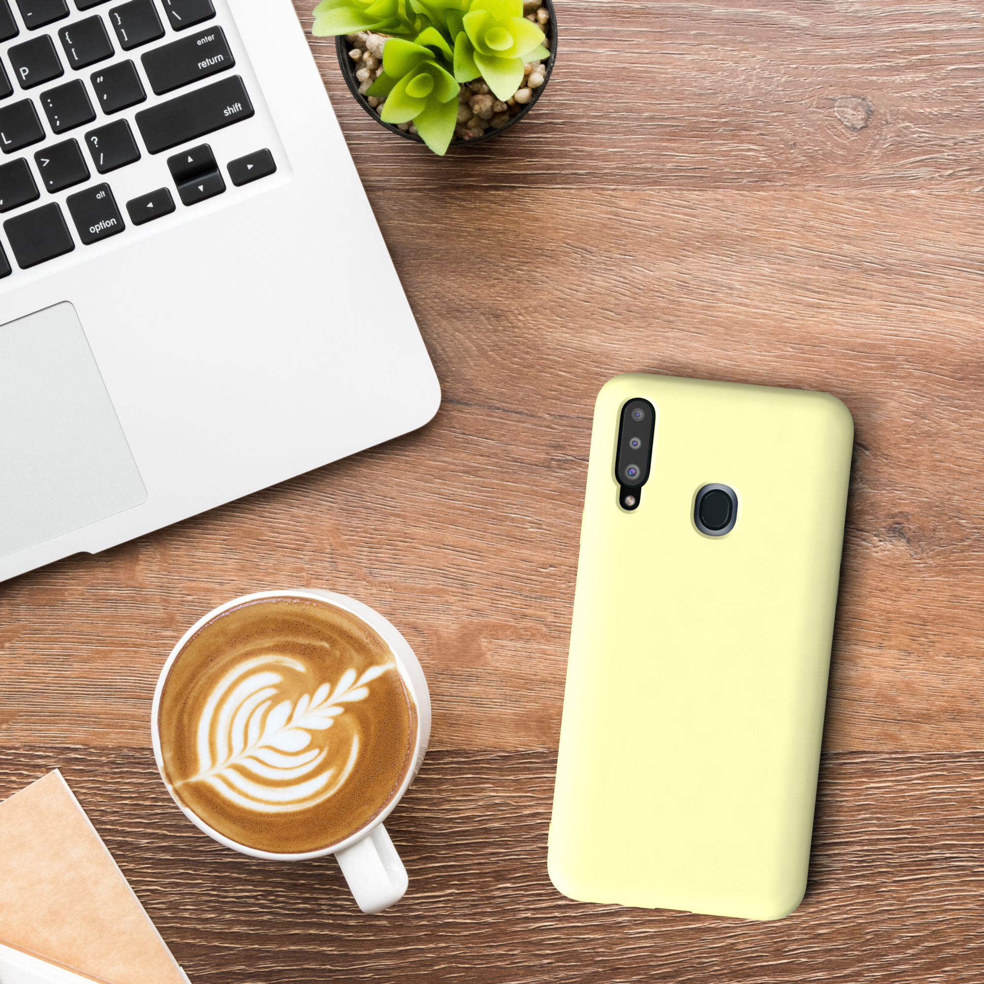 Eine Handyhülle und ein Laptop mit Kaffee. Das Gehäuse ist gelb.