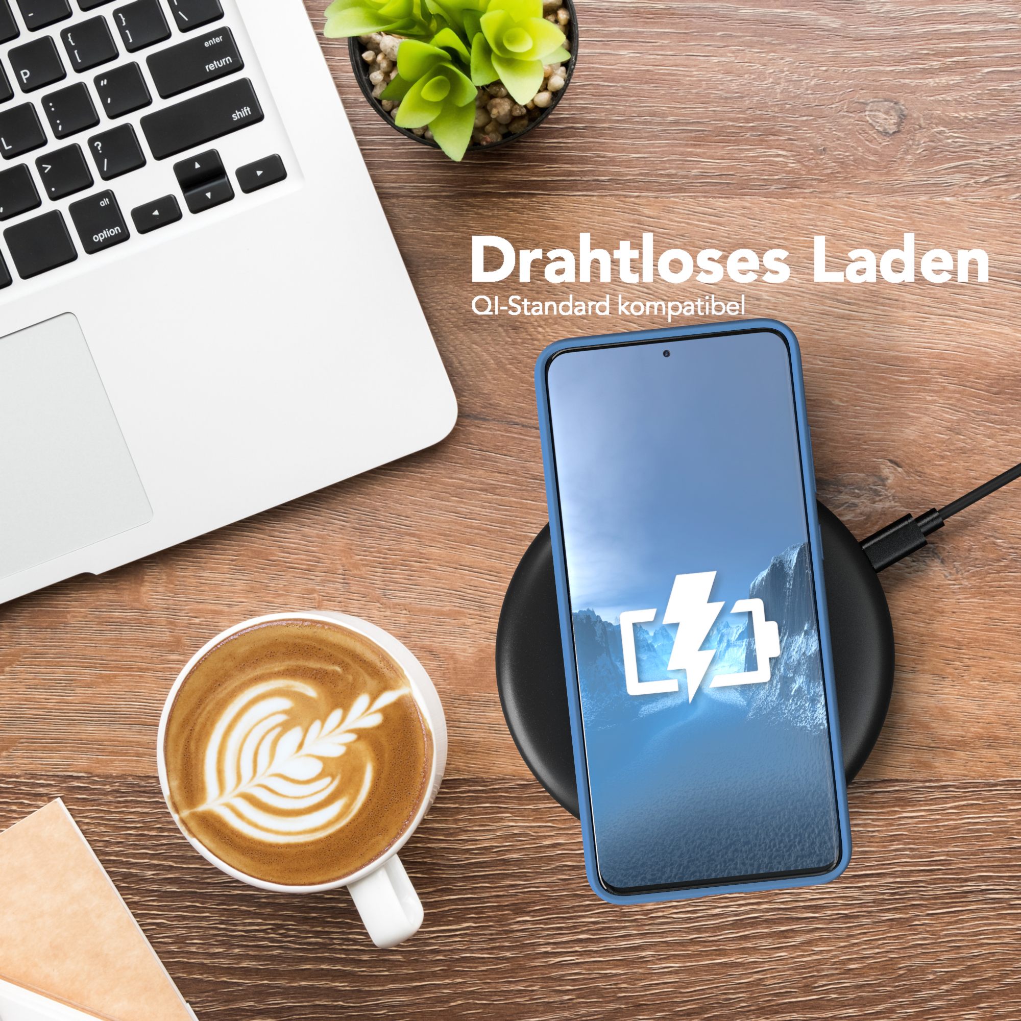 Telefon wird drahtlos auf einem Ständer geladen, neben einem Laptop und einer Tasse Kaffee.