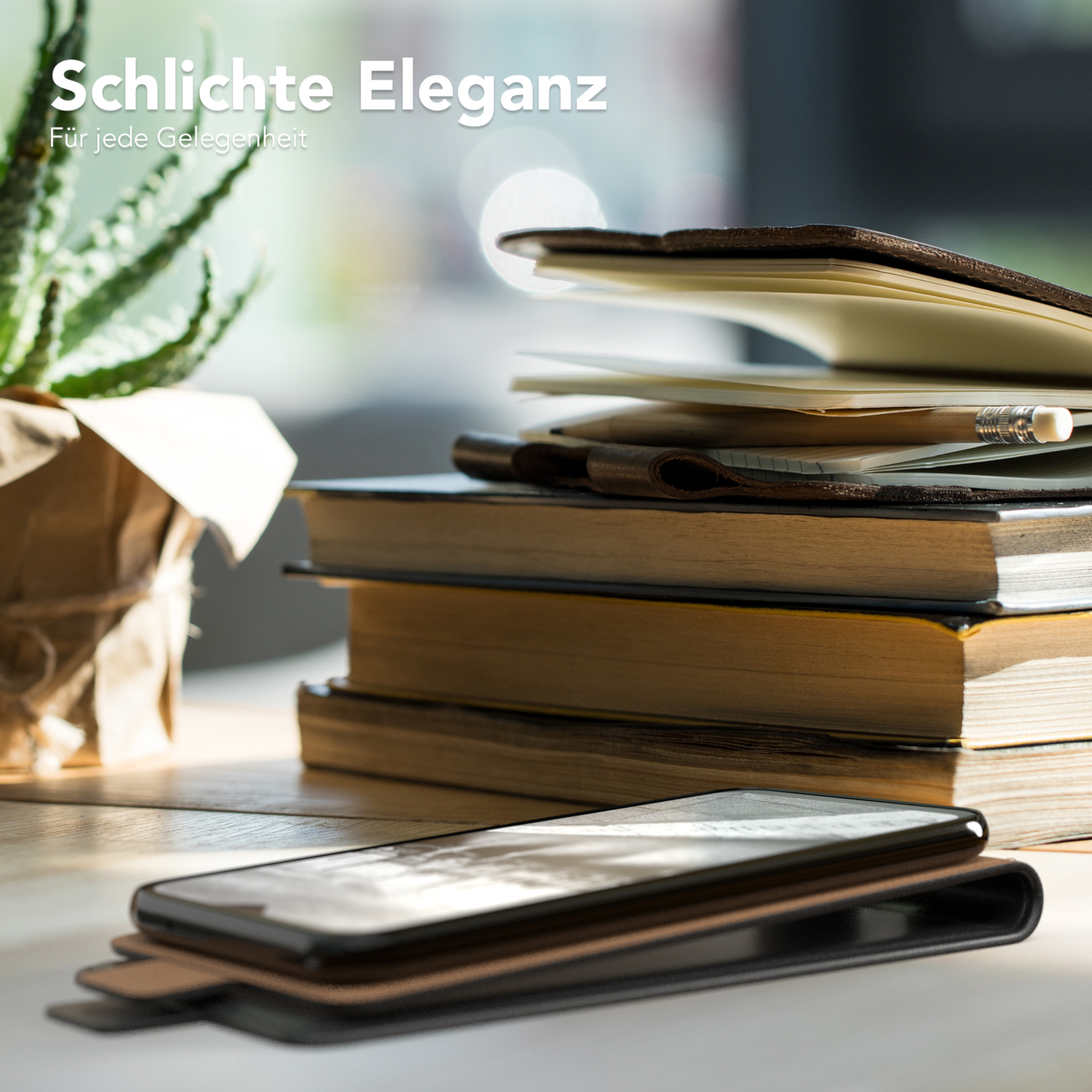 Telefon in einer Hülle, Bücher und eine Pflanze. Warmes Licht und verschwommener Hintergrund.