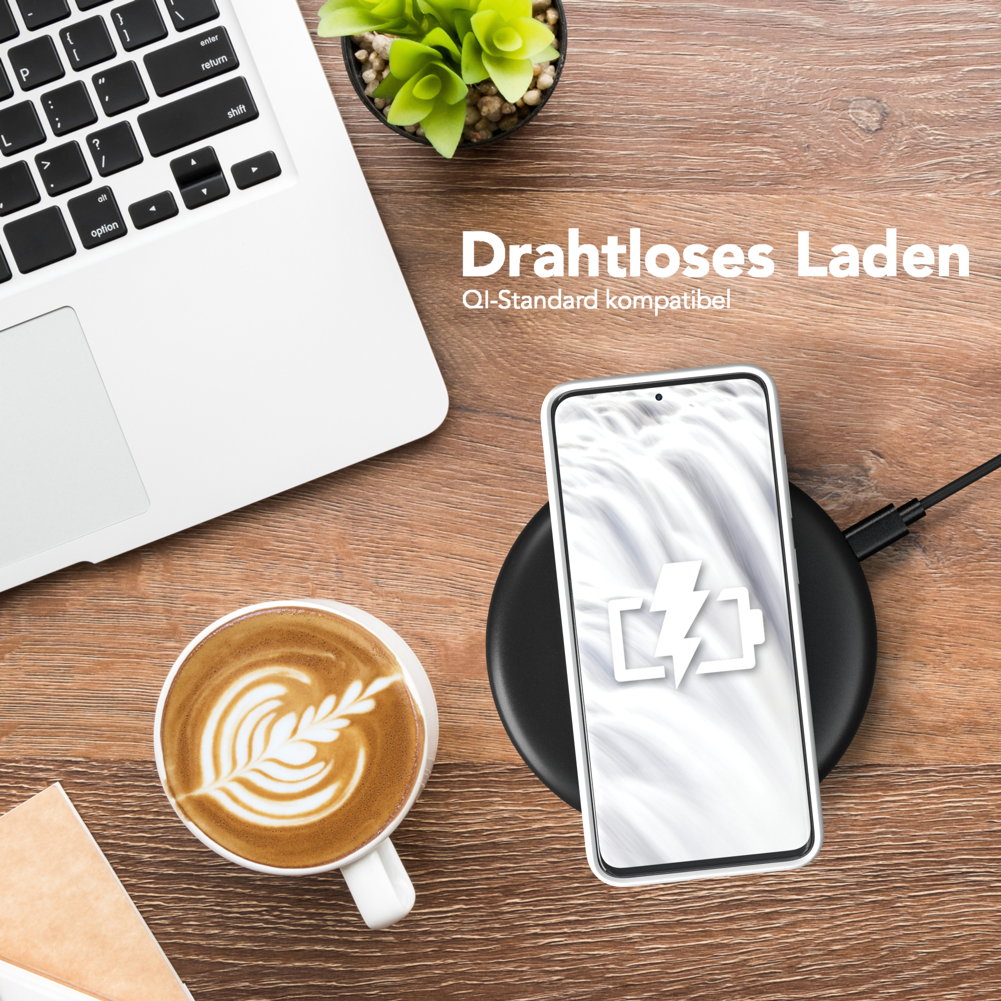 Telefon und Kaffeetasse auf Holztisch. Ein kabelloses Ladegerät ist auch da.