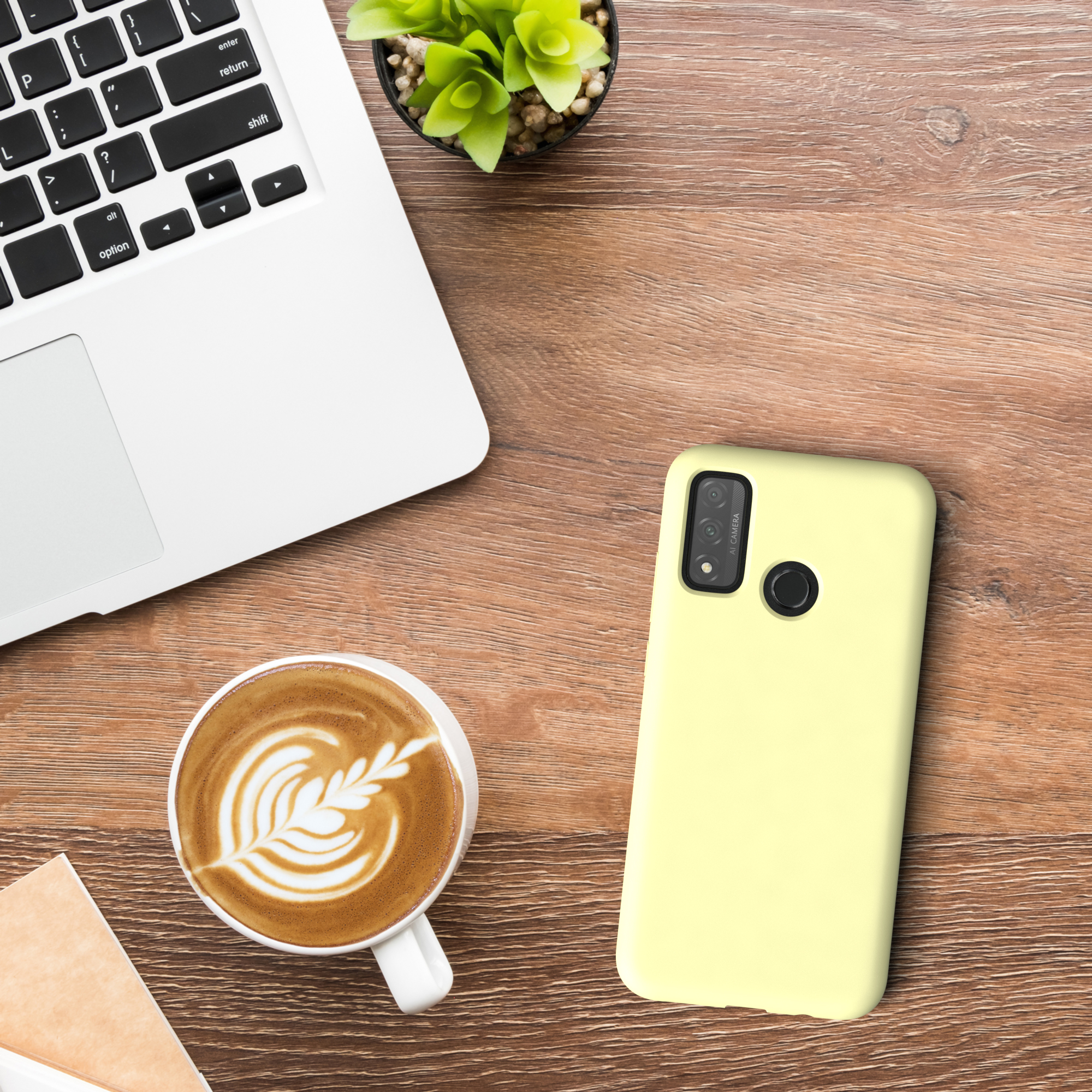 Laptop, Kaffee, Handyhülle und eine Pflanze auf einem Holztisch.