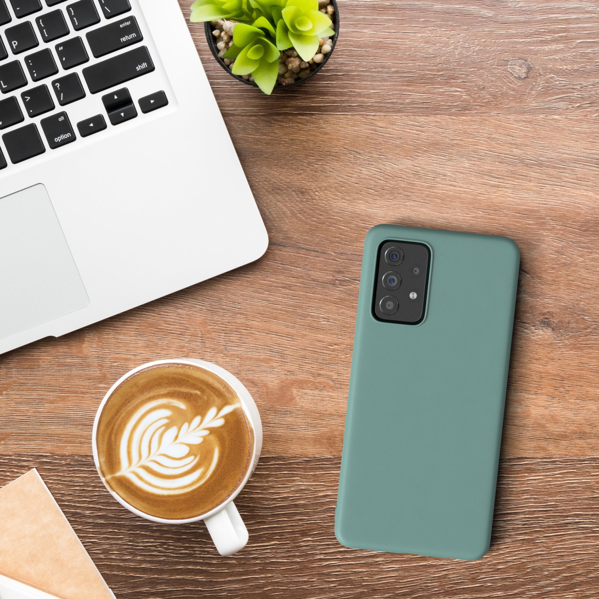 Draufsicht auf einen Schreibtisch mit Laptop, Kaffee und Handyhülle.
