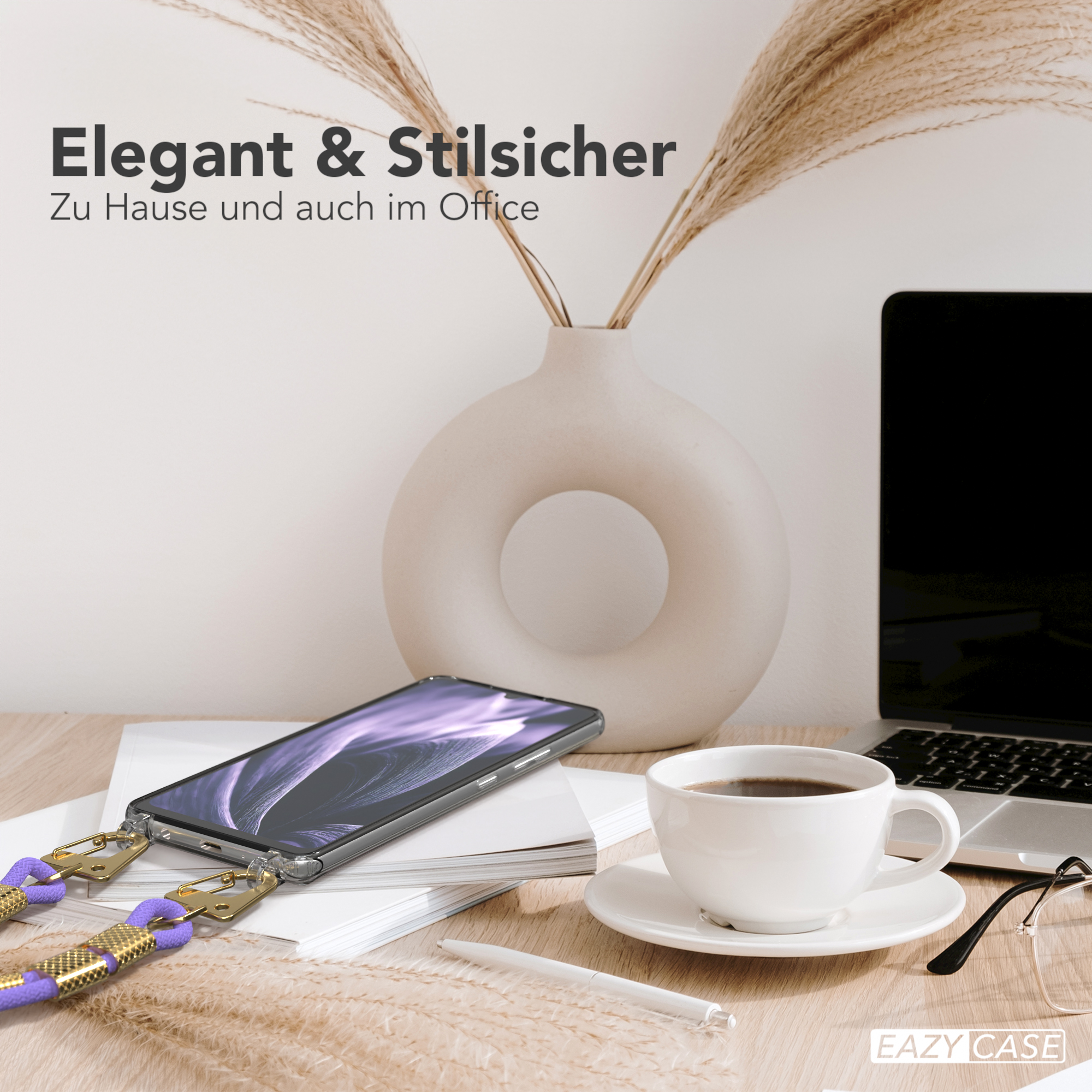 Ein Telefon mit Lanyard auf dem Schreibtisch. Eine Vase mit Pflanzen und ein Laptop sind im Hintergrund.