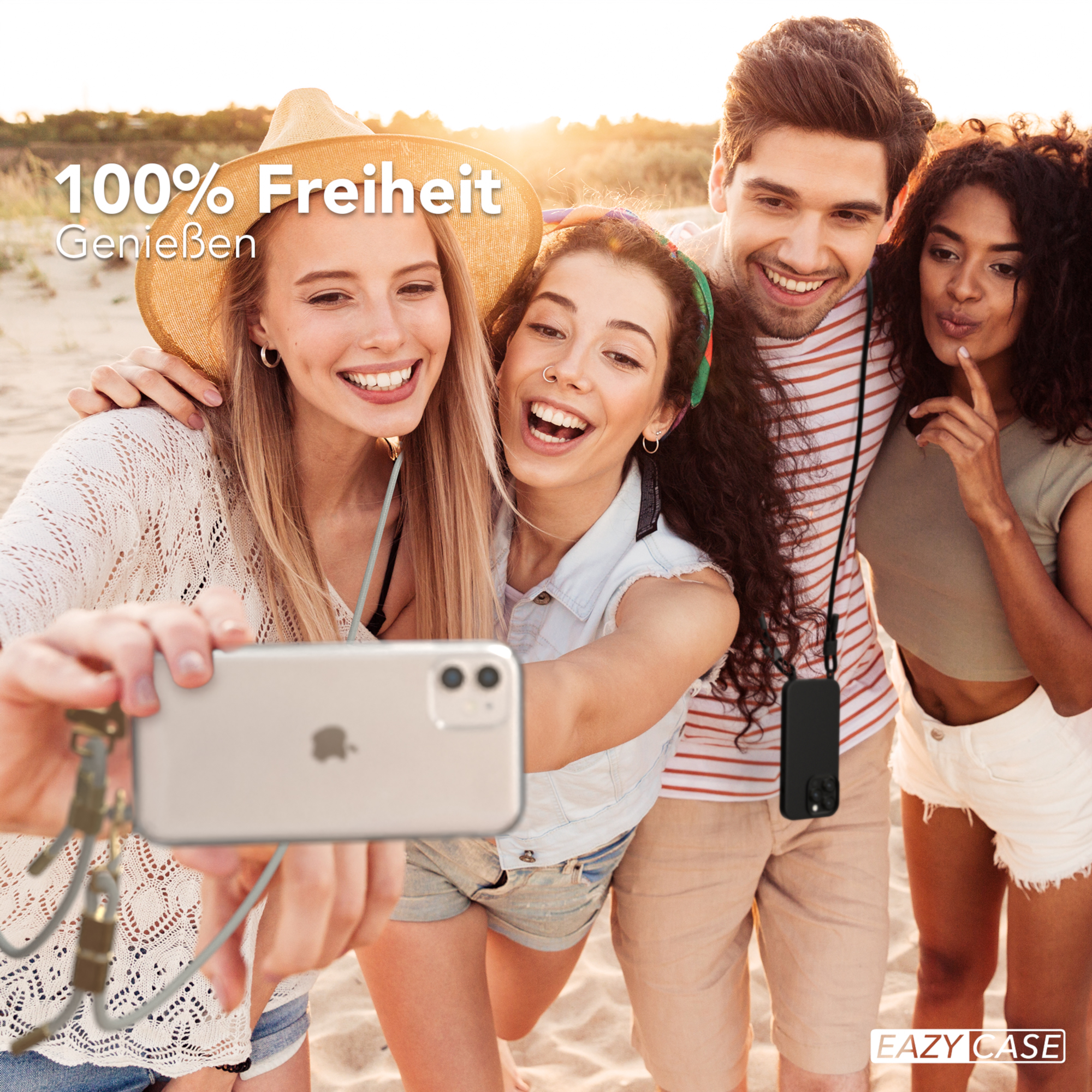 Vier Personen machen ein Selfie am Strand. Sie lächeln und halten ein Telefon mit einem Schlüsselband.