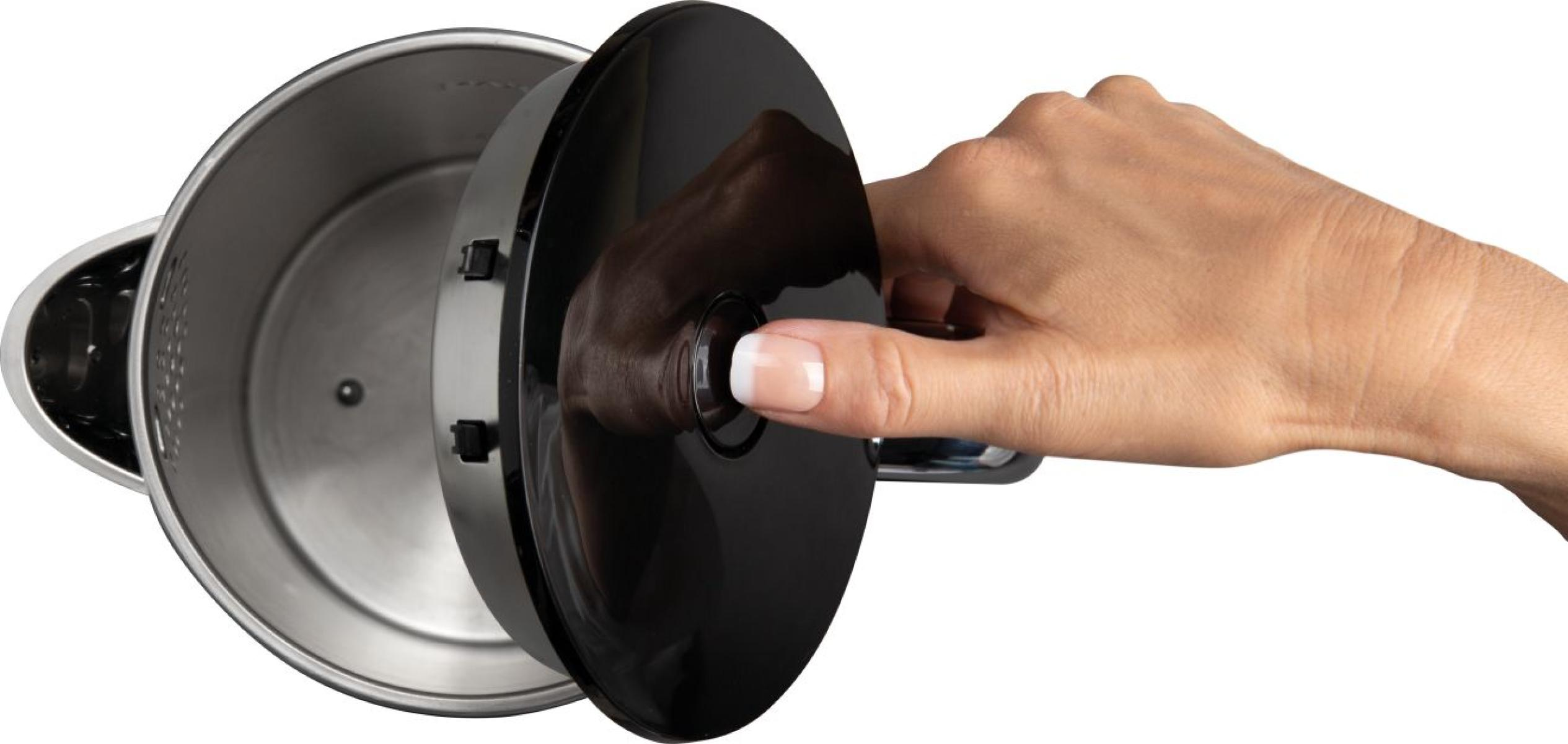 Eine Hand drückt einen Knopf auf einem schwarzen Wasserkocherdeckel. Das Innere des Wasserkochers ist Edelstahl.