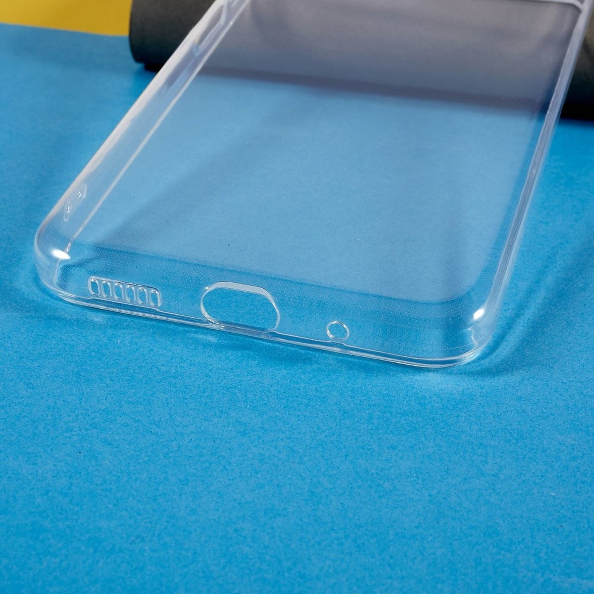Eine transparente Handyhülle auf einer blauen Oberfläche. Die Hülle hat Löcher für die Funktionen des Telefons.