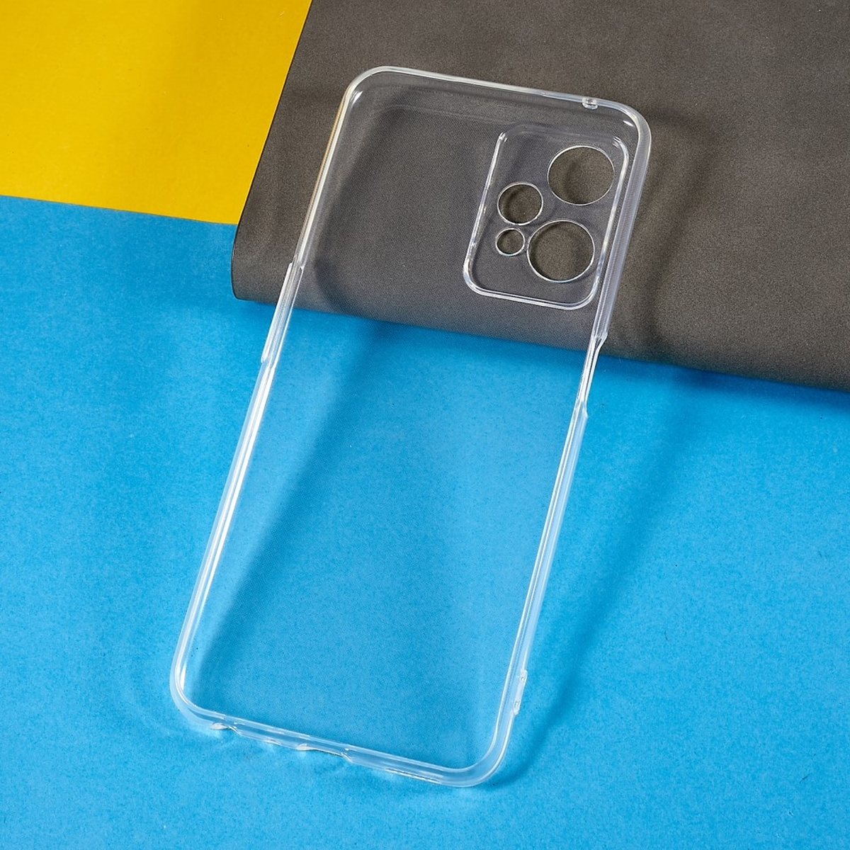 Transparente Handyhülle vor blauem, gelbem und grauem Hintergrund. Hülle hat Kameralöcher.