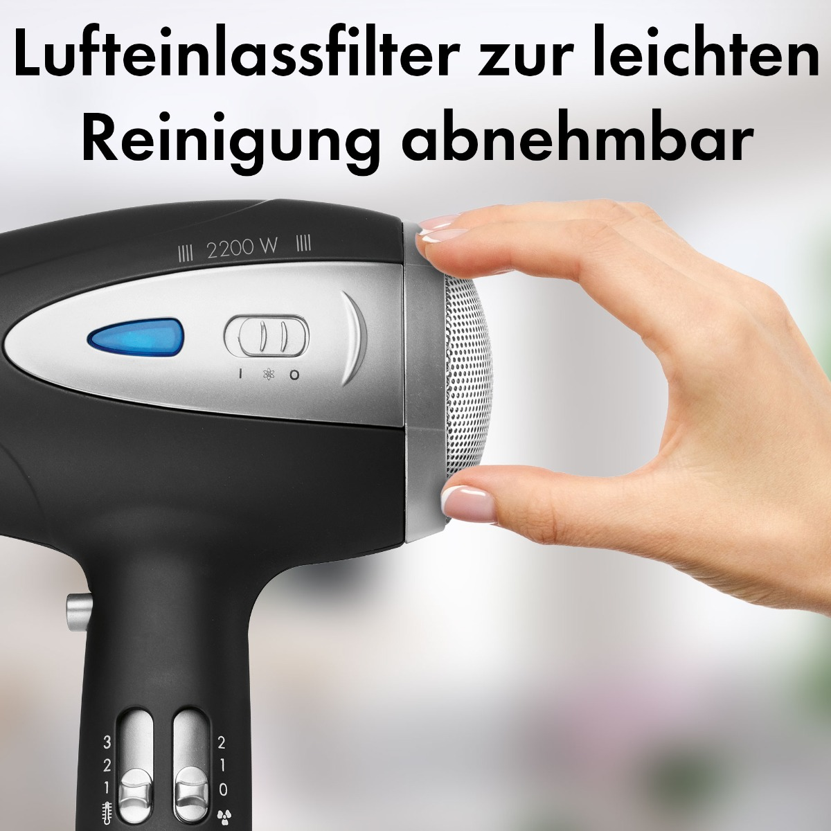 Ręka wyjmująca filtr wlotu powietrza z czarno-srebrnej suszarki do włosów.