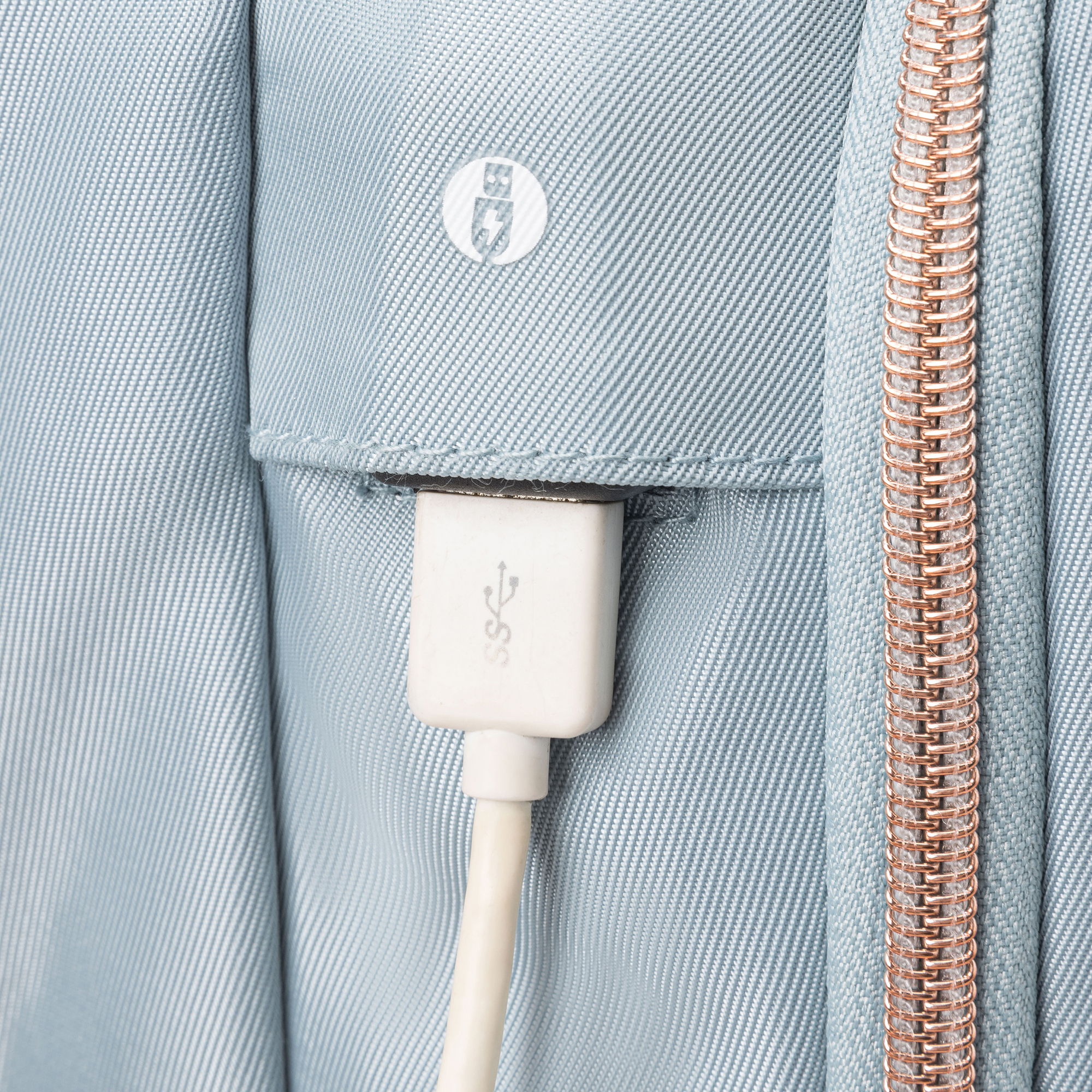 Ein USB-C-Kabel ist in einen hellblauen Stoff gesteckt. Rechts ist ein roségoldener Reißverschluss zu sehen.
