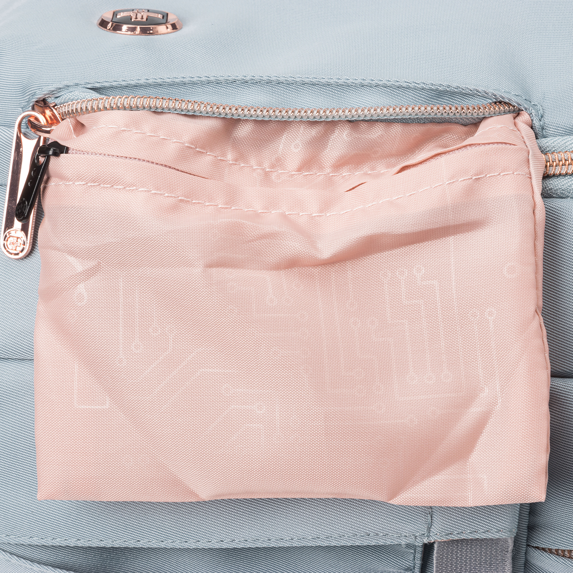Nahaufnahme einer hellblauen Rucksacktasche mit rosa Stoffinnenseite und Reißverschluss.