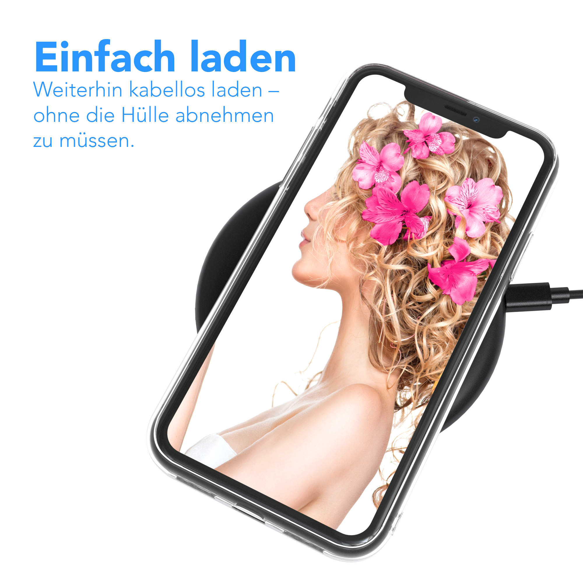Das Gesicht einer Frau ist auf einem Telefon zu sehen, das kabellos geladen wird. Auf dem Bildschirm sind rosa Blumen zu sehen.