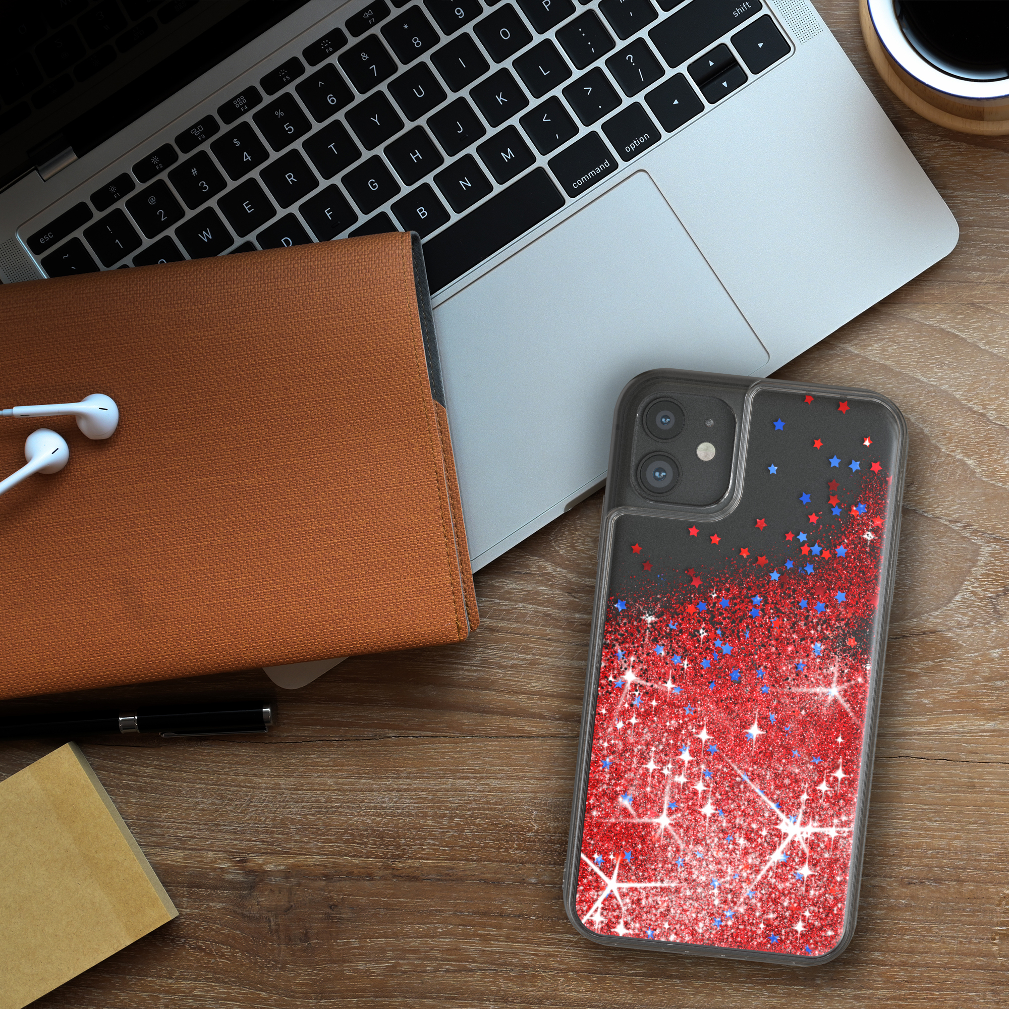 Handyhülle mit Glitzer und Sternen, auf einem Holzschreibtisch mit Laptop und Zubehör.