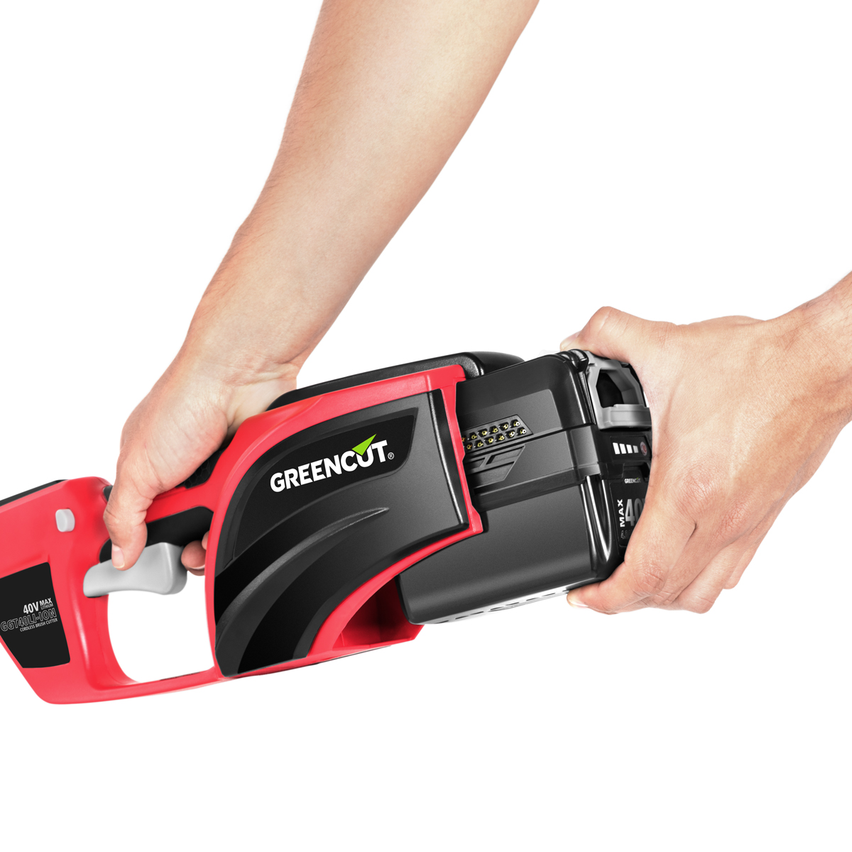 Manos insertando una batería en una motosierra Greencut roja y negra.