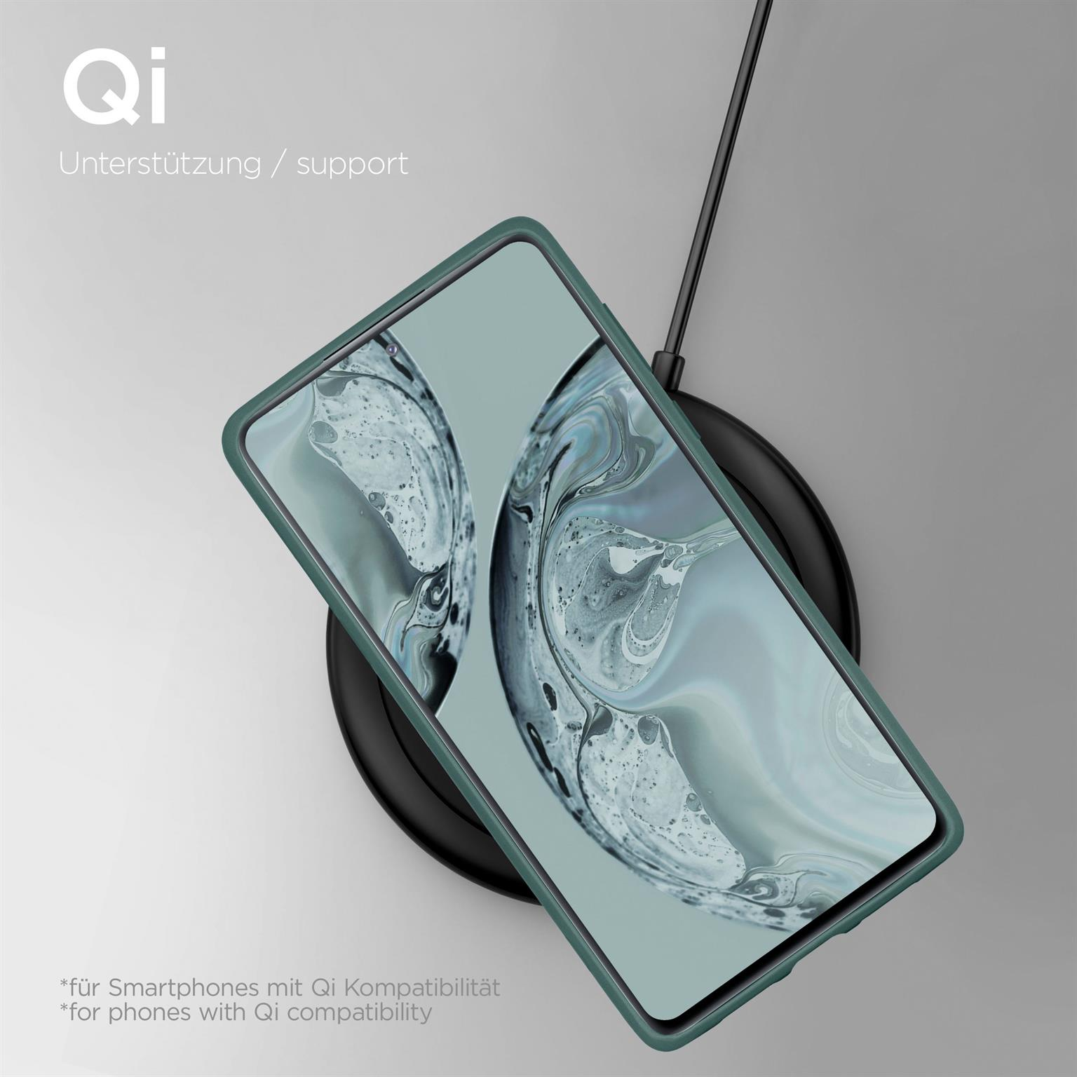 Ein Telefon in einer grünen Hülle, das auf einem schwarzen Qi-Ladegerät geladen wird.