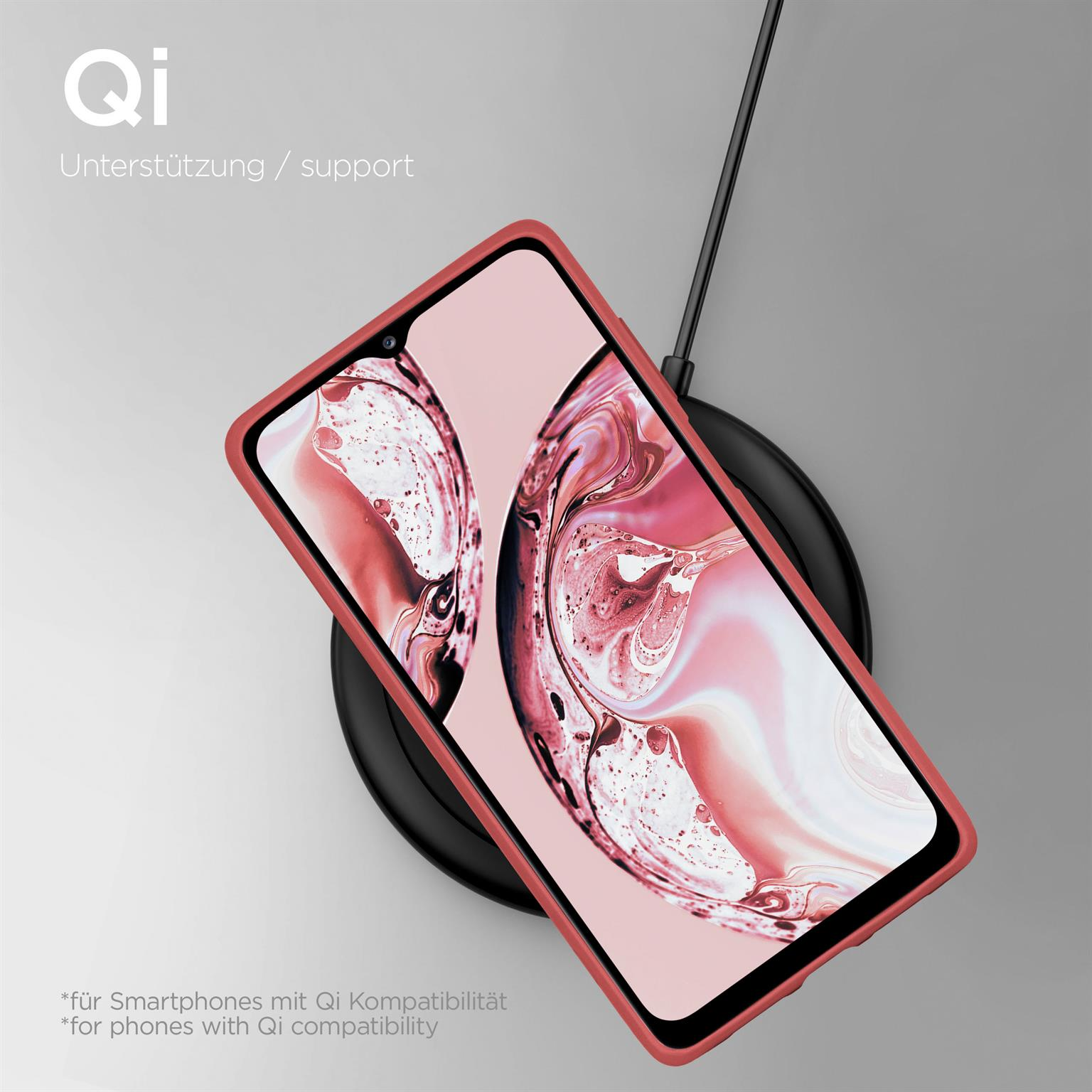 Ein Telefon in roter Hülle auf einem kabellosen Ladegerät, mit Text zur Qi-Kompatibilität.