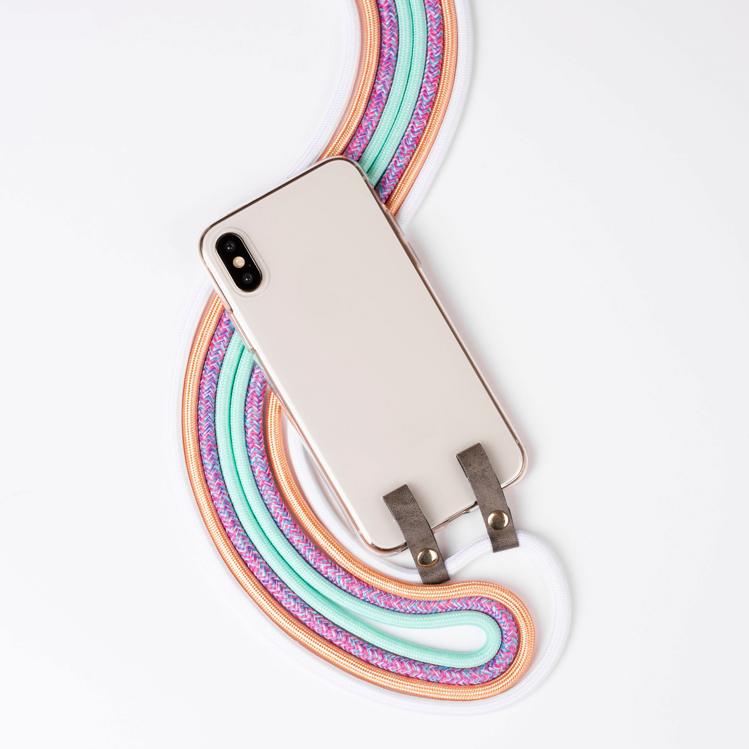 Telefon mit Regenbogenfarben-Gurt auf weißer Oberfläche. Gurt ist befestigt.