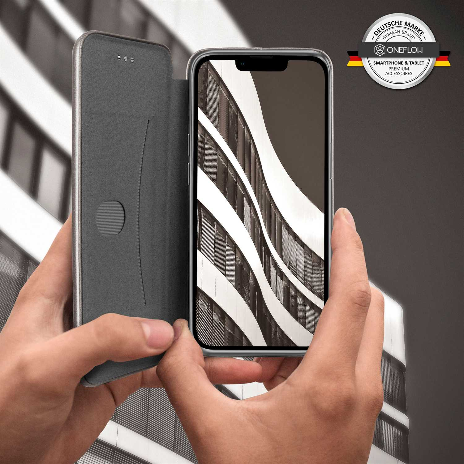 Person hält ein Telefon in einer Hülle und zeigt ein modernes Architektur-Bild auf dem Bildschirm.
