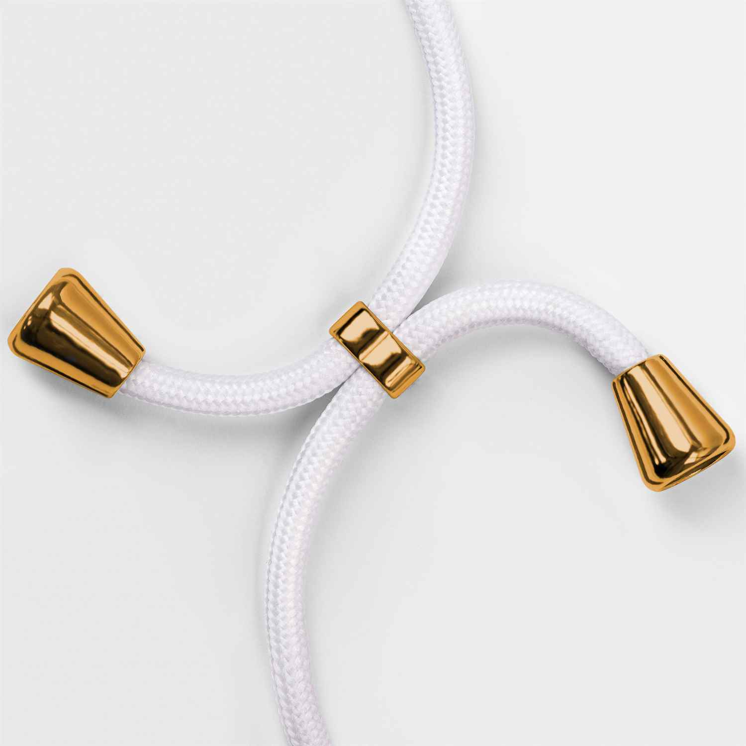 Nahaufnahme eines weißen Schlüsselbands mit goldenen Akzenten. Das Schlüsselband endet in goldenen Kegeln.