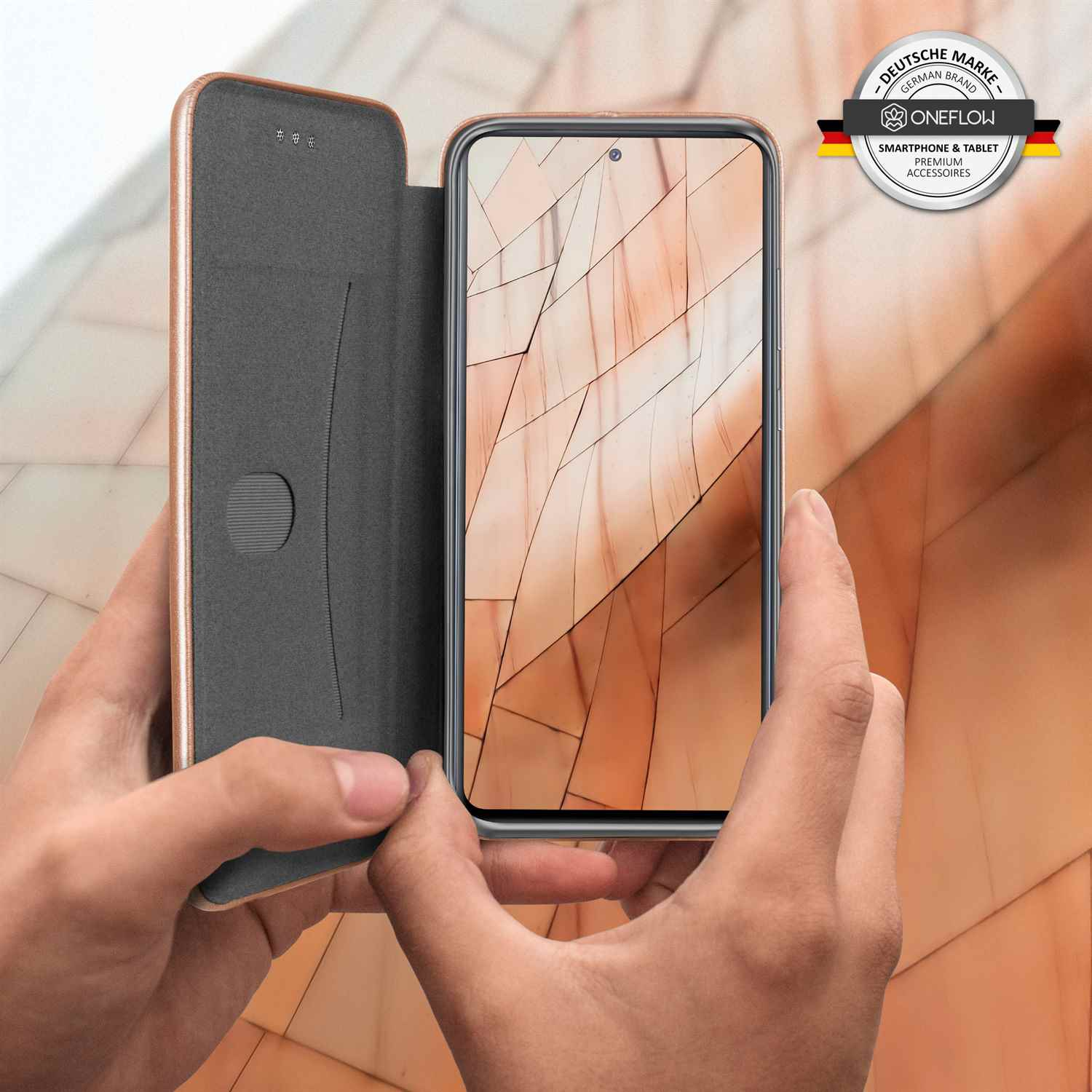 Eine Handyhülle wird geöffnet gehalten. Der Bildschirm zeigt ein geometrisches Design.