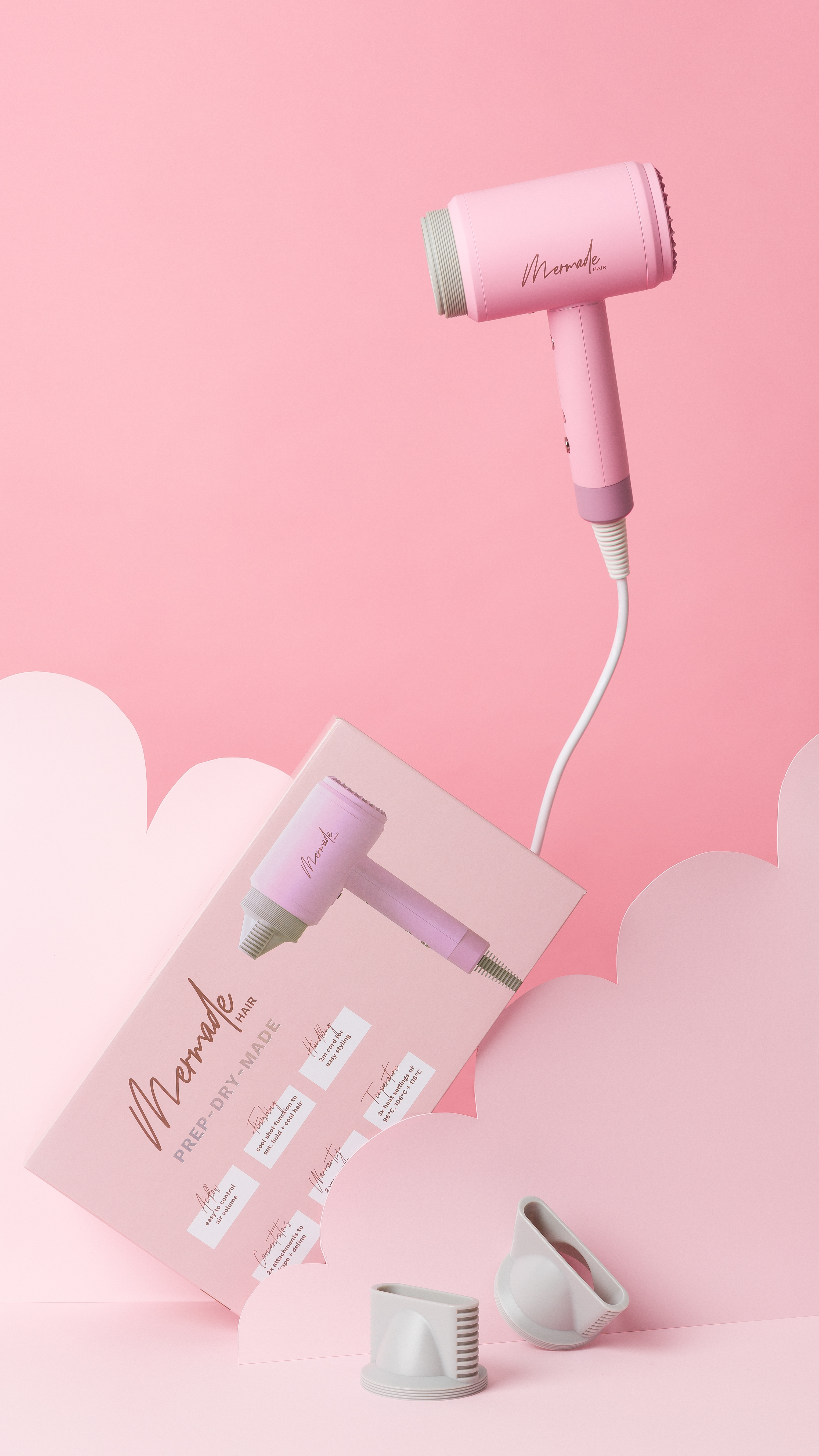 Rosa Haartrockner und Schachtel mit Zubehör auf rosa Hintergrund. Auf der Schachtel steht 'Memade hair'.