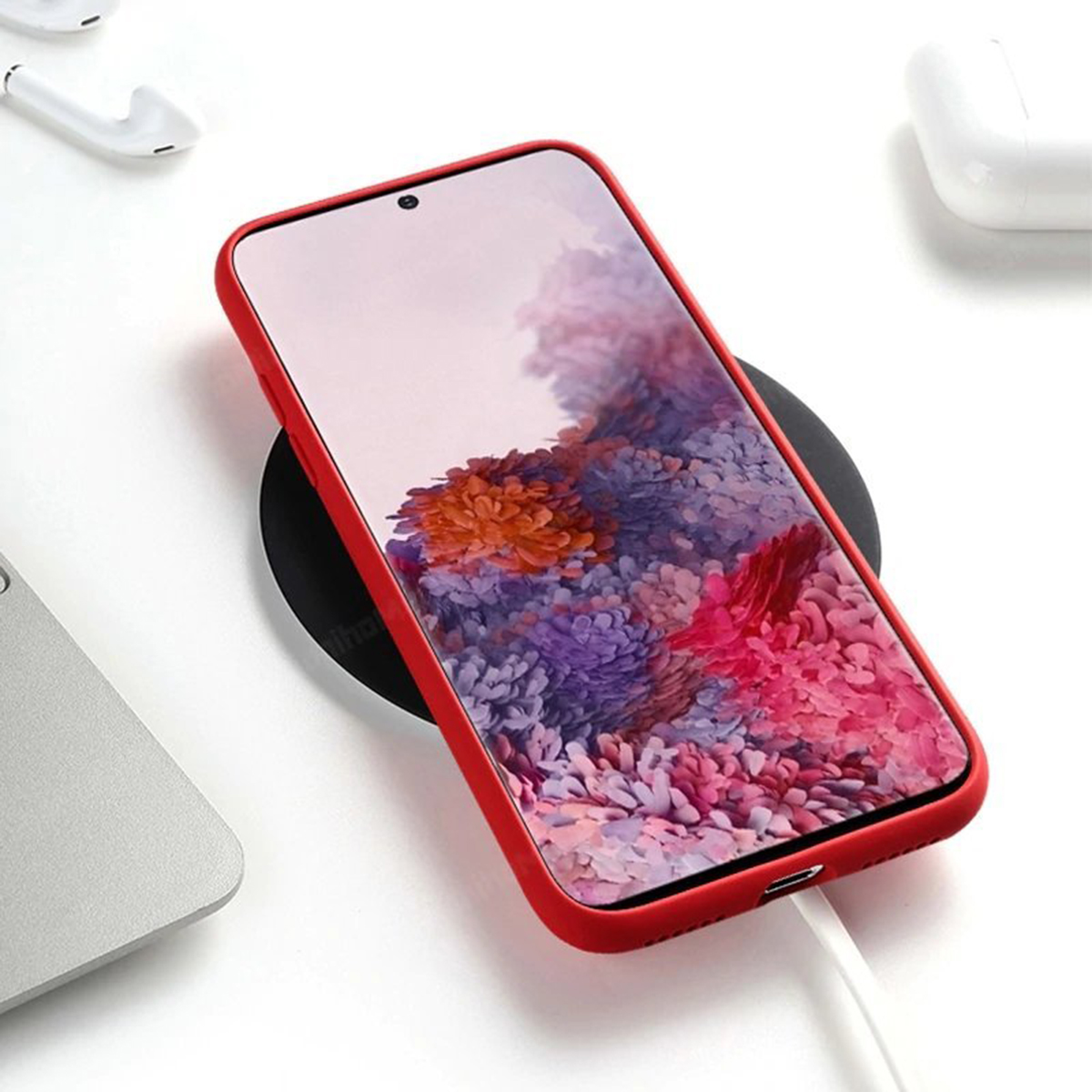 Rotes Telefon in roter Hülle auf einem kabellosen Ladegerät.