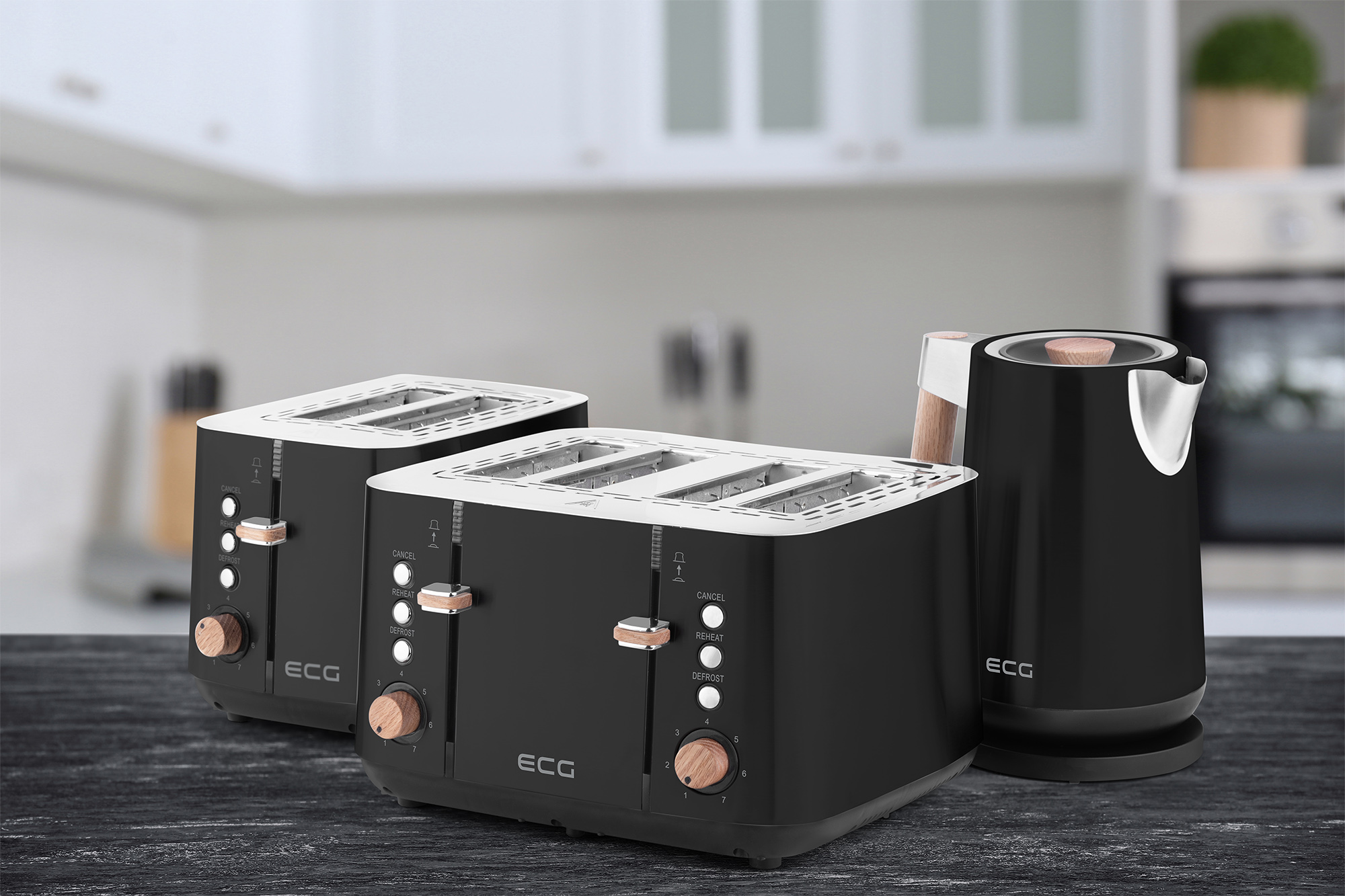 Schwarze Toaster und Wasserkocher auf einem Holztisch in einer Küche. Weiße Schränke im Hintergrund.