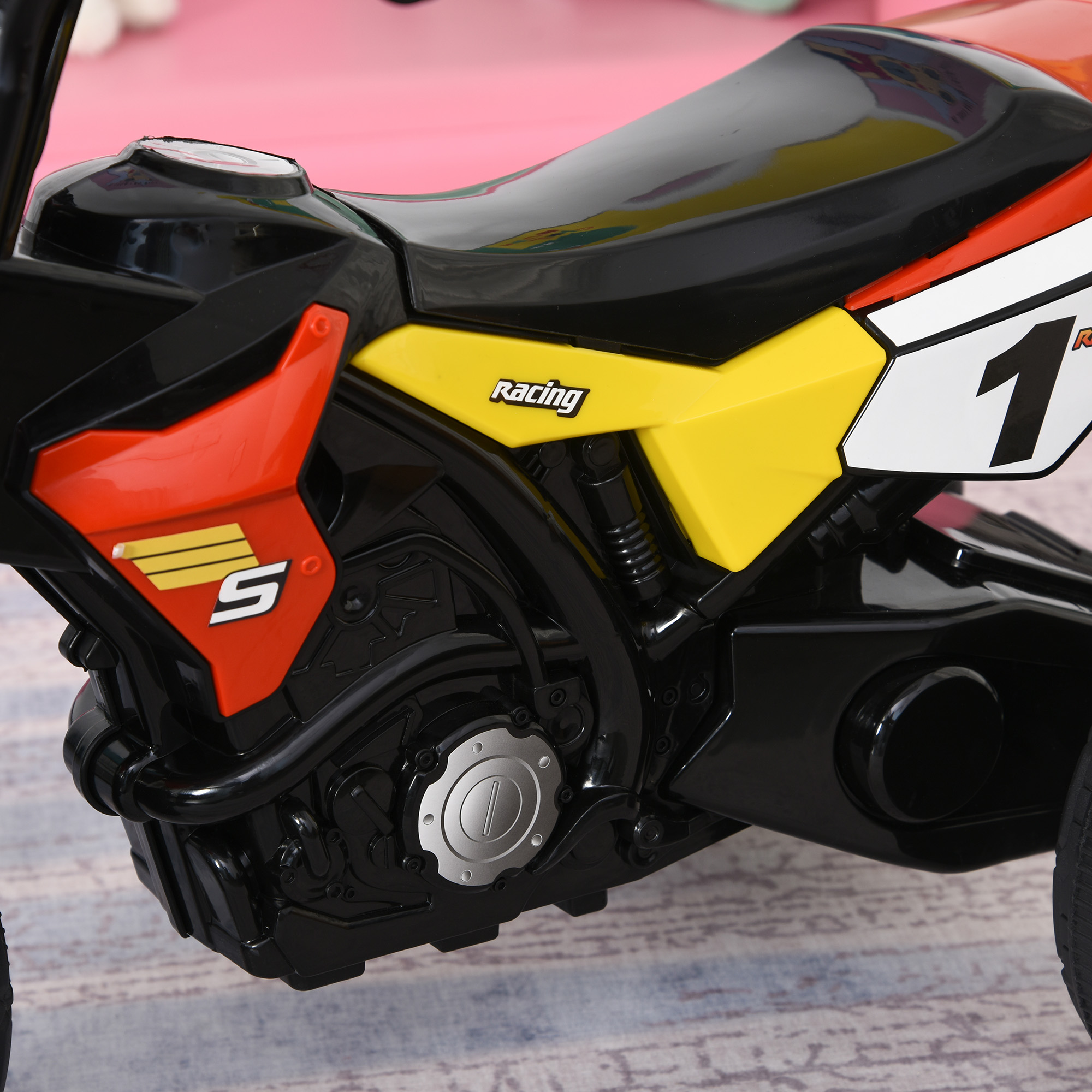 Motocicleta de juguete, colores negro, rojo, amarillo y blanco. El número 1 está en el lateral.