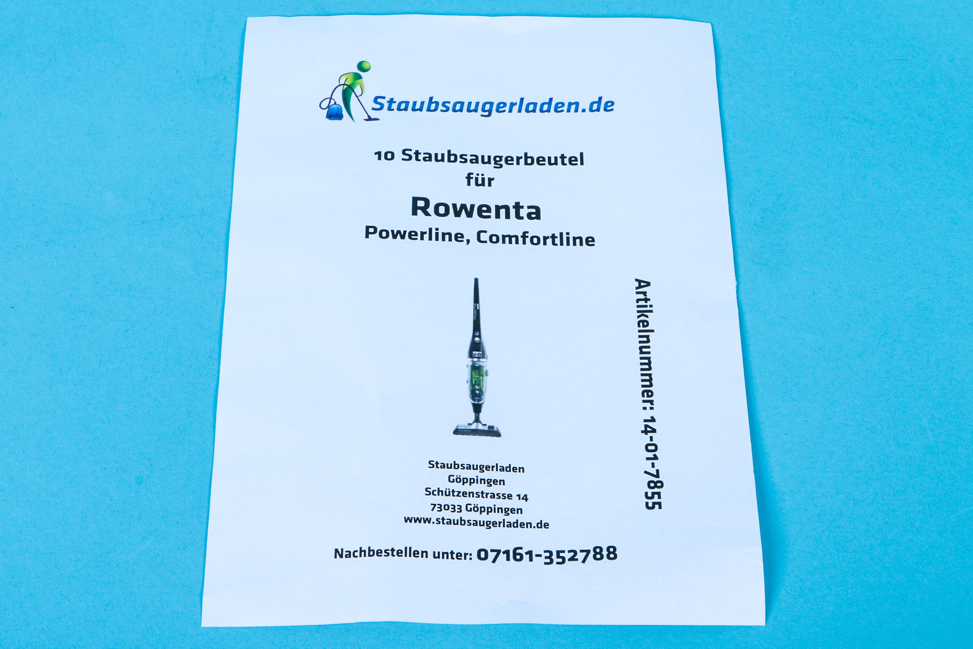 Ein weißes Papier mit Text, einem Logo und einer Staubsauger-Illustration auf blauer Oberfläche.