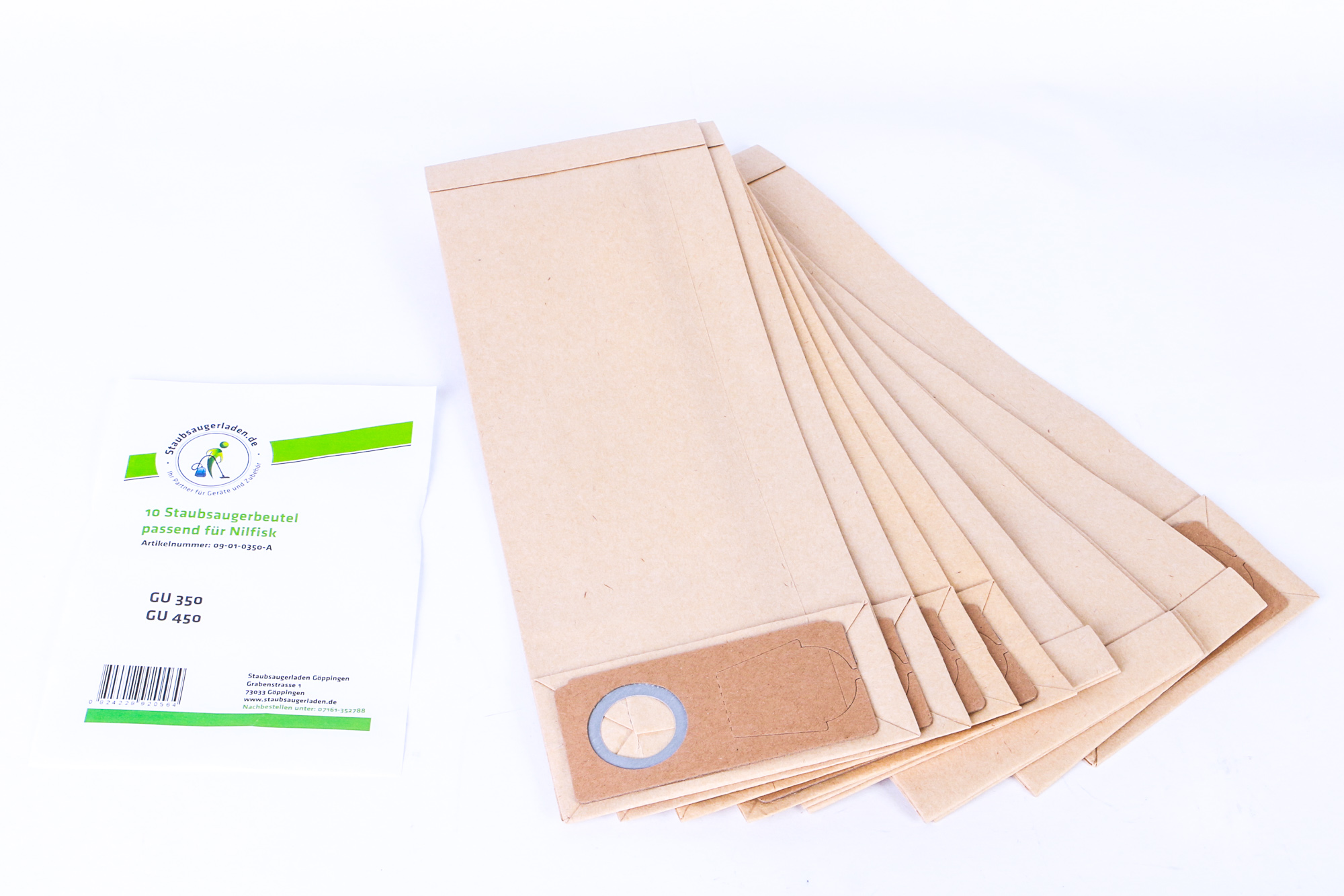 Staubsaugerbeutel und ihre Verpackung liegen auf einer weißen Oberfläche. Die Beutel sind beige.