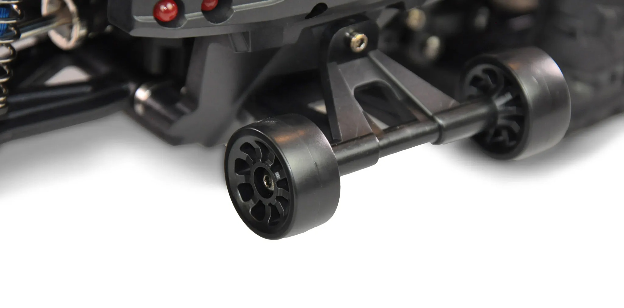Nahaufnahme der Hinterräder eines RC-Cars, schwarz-graue Details, weißer Hintergrund.