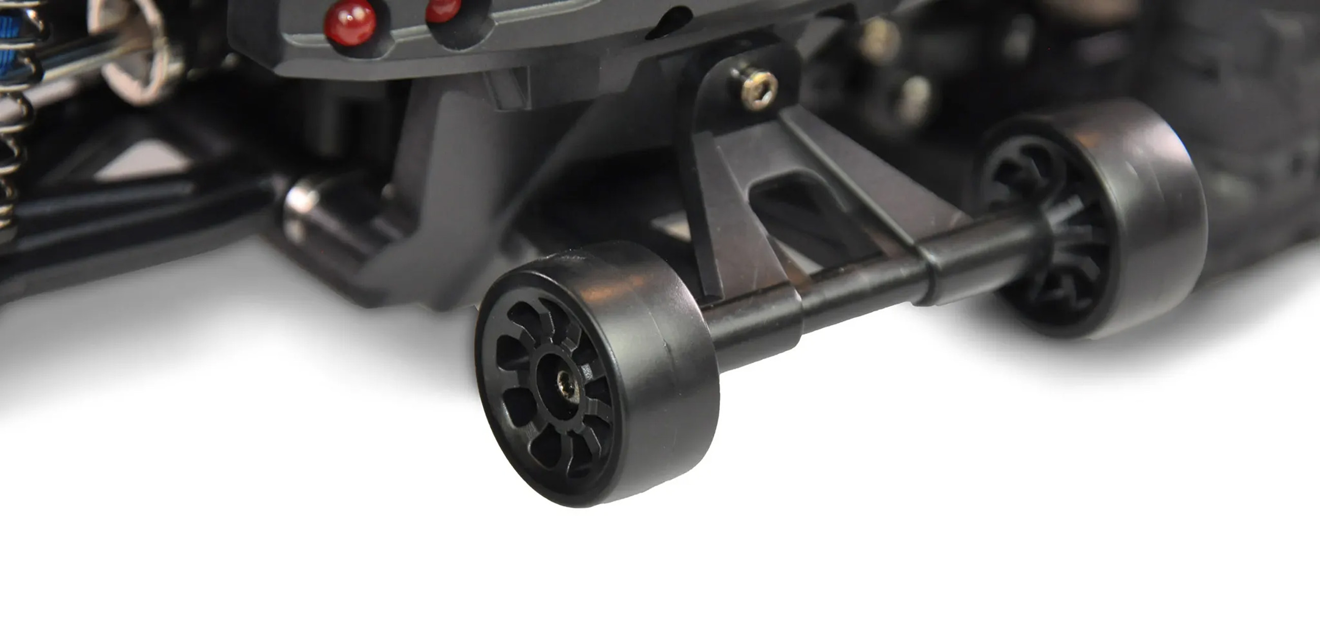 Gros plan des roues arrière et de l'essieu d'une voiture RC noire, fond blanc.