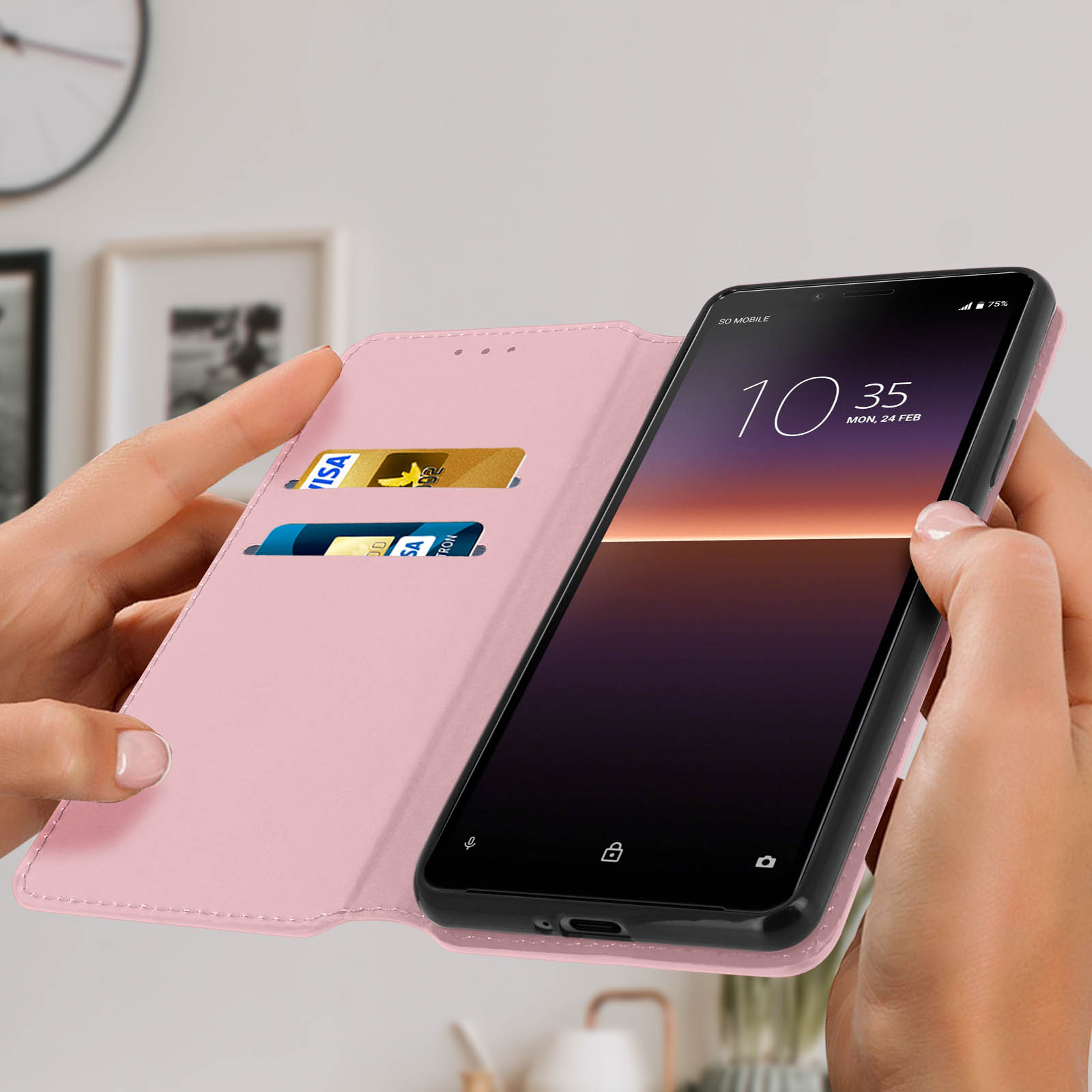 Una custodia rosa per telefono è aperta, rivelando un telefono con orologio digitale. Ci sono carte di credito.