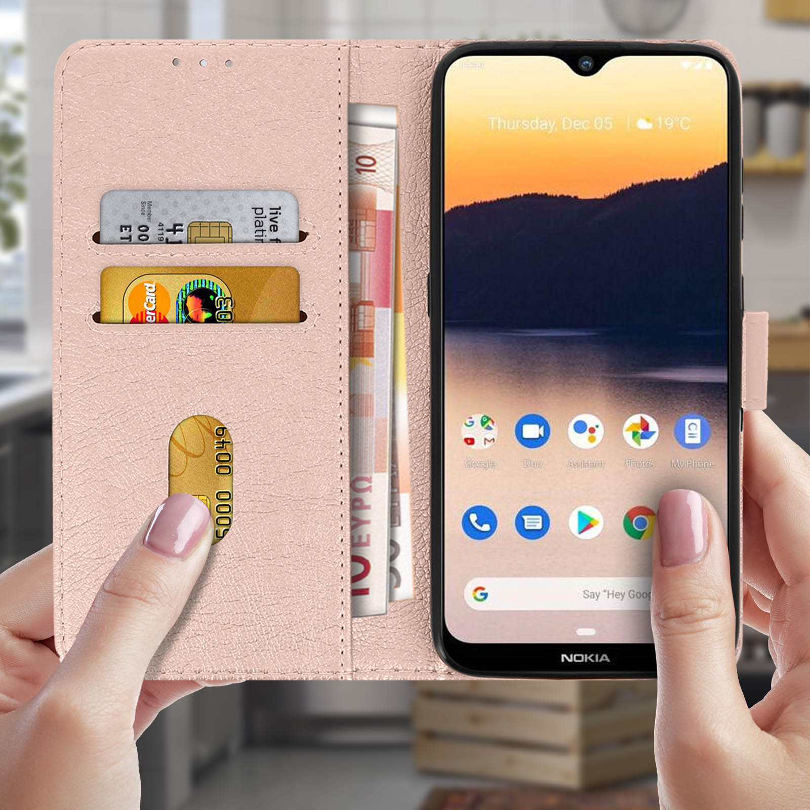 Una custodia rosa per telefono con telefono e carte all'interno, tenuta in mano.