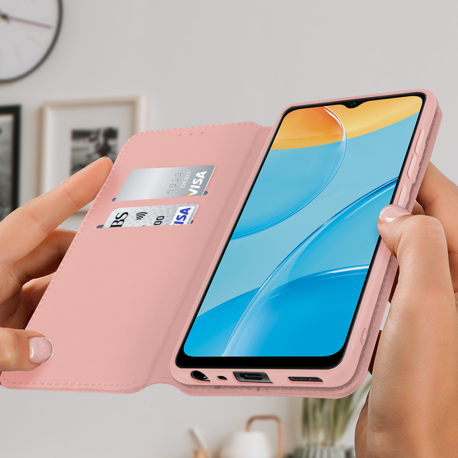 Una custodia per telefono rosa con un telefono all'interno, tenuta in mano davanti a uno sfondo sfocato.