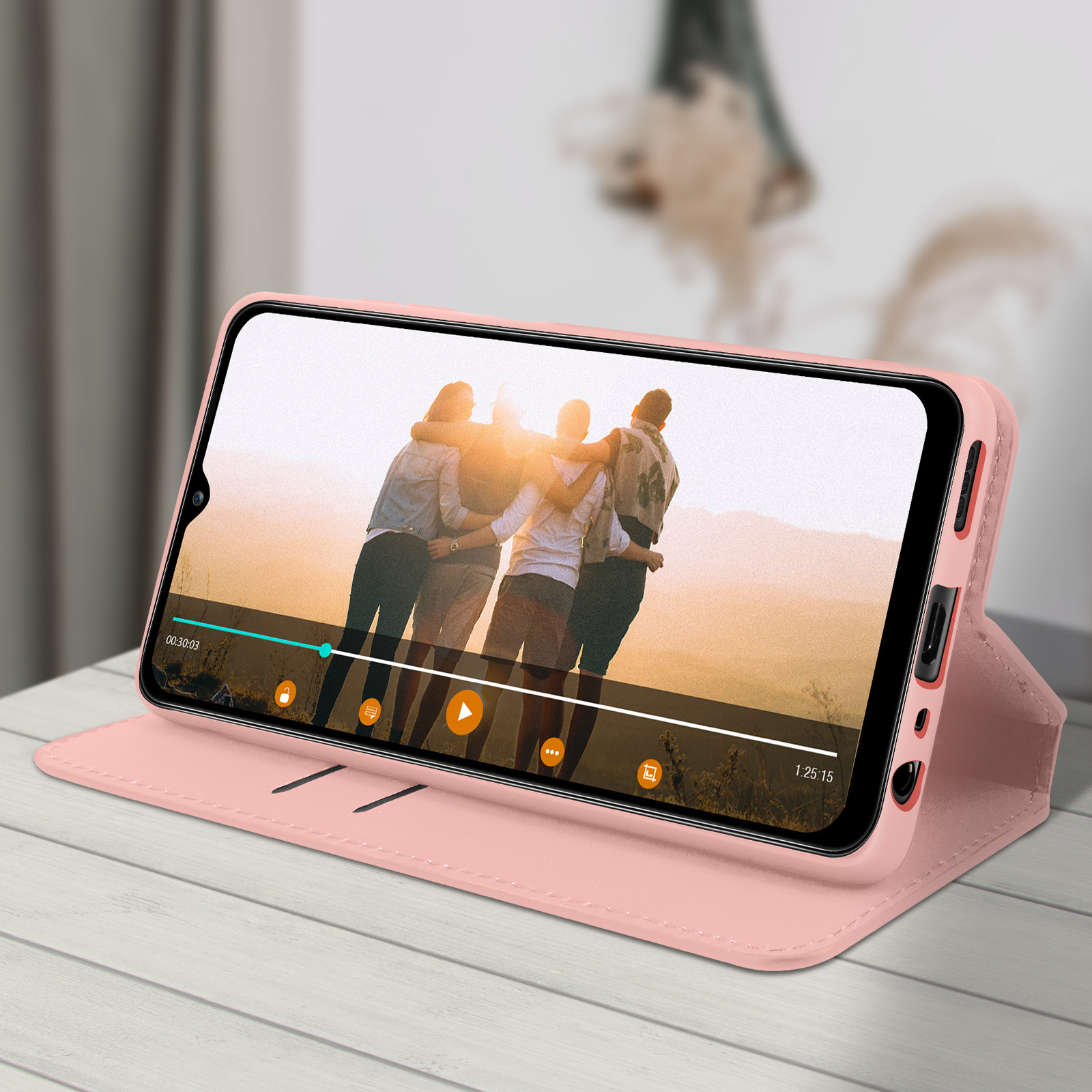 Un telefono è in una custodia rosa e mostra un video. Le persone si abbracciano.