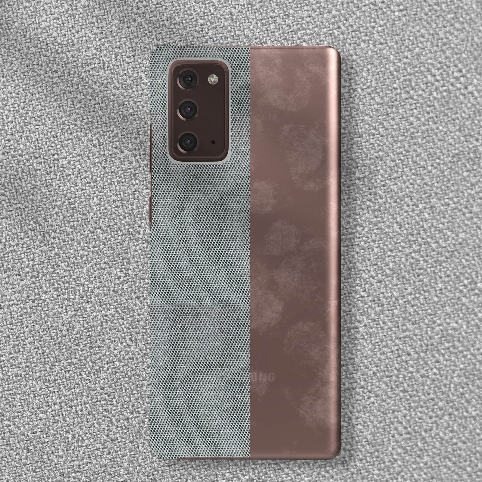 Smartphone mit gemusterter Rückseite und kupferfarbener Rückseite. Das Telefon liegt auf grauer Oberfläche.