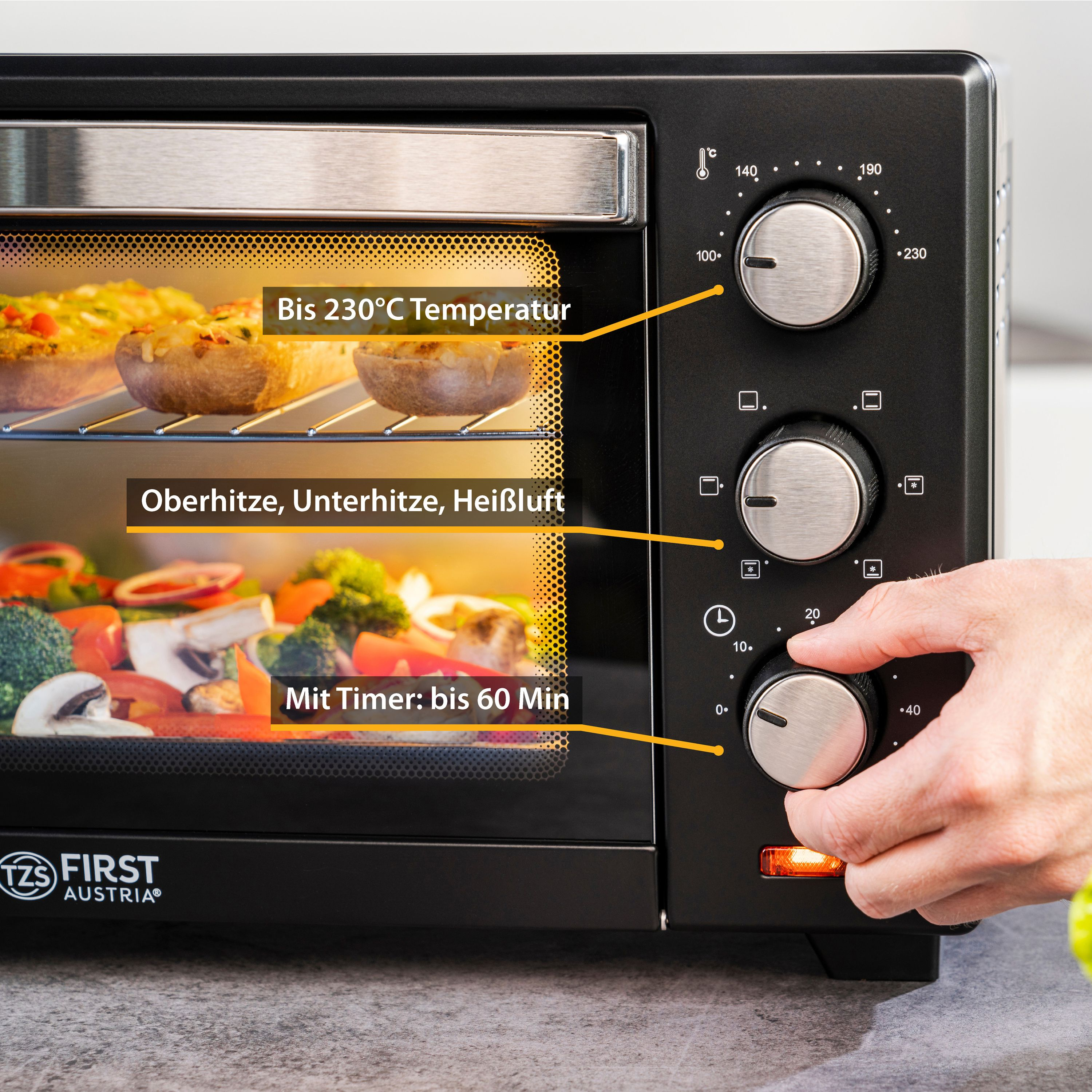 Schwarzer Ofen mit Bedienknöpfen. Essen im Inneren. Beschriftungen auf Deutsch. Hand stellt Timer ein.