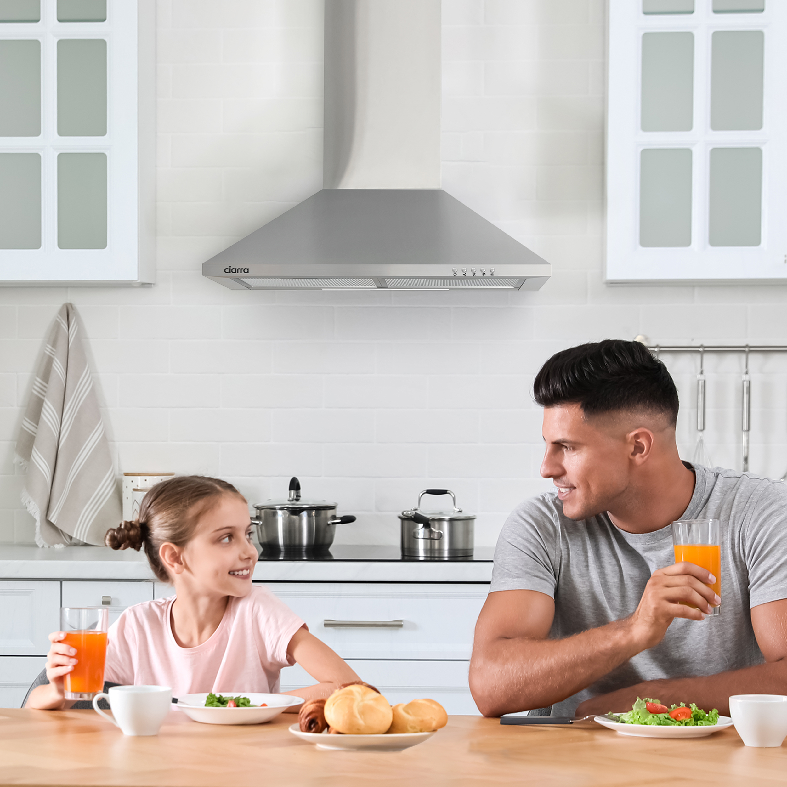 Une famille, un père et sa fille, assis à une table, buvant du jus.