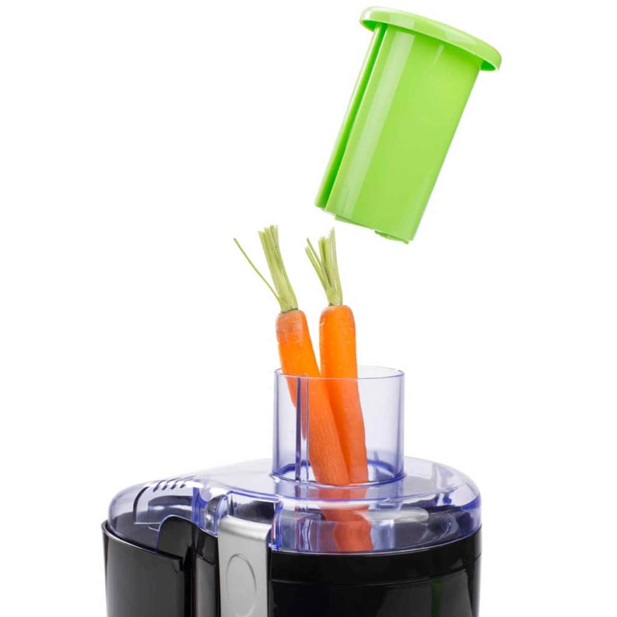 Un procesador de alimentos con zanahorias y un tubo verde para meterlas.