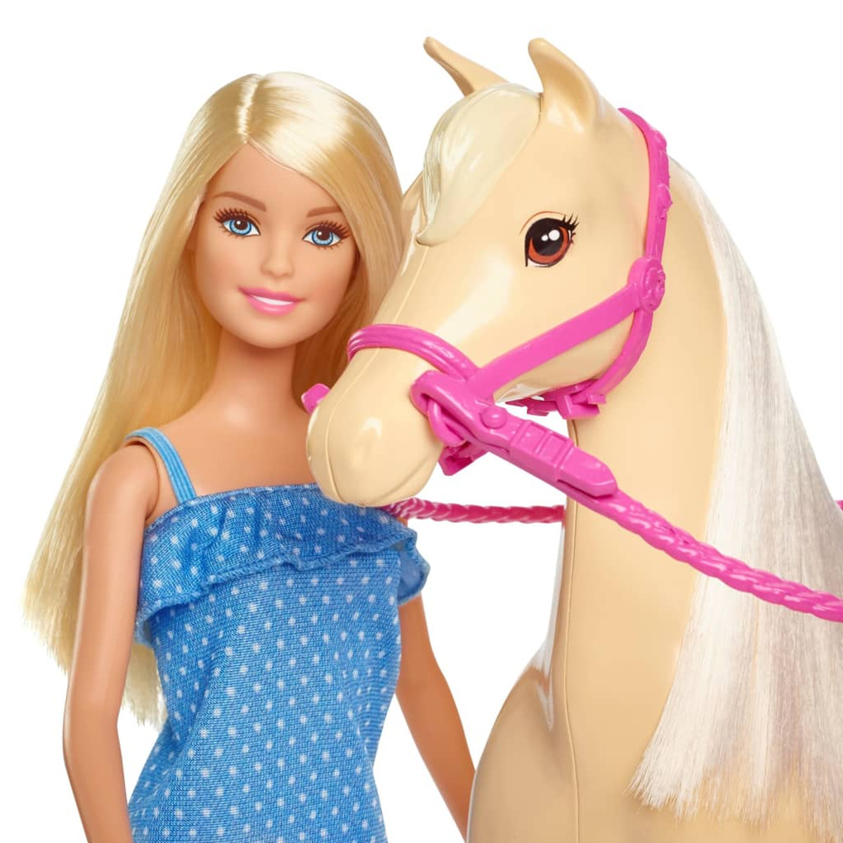 Una bambola Barbie con lunghi capelli biondi in un vestito blu, in piedi accanto a un cavallo marrone.